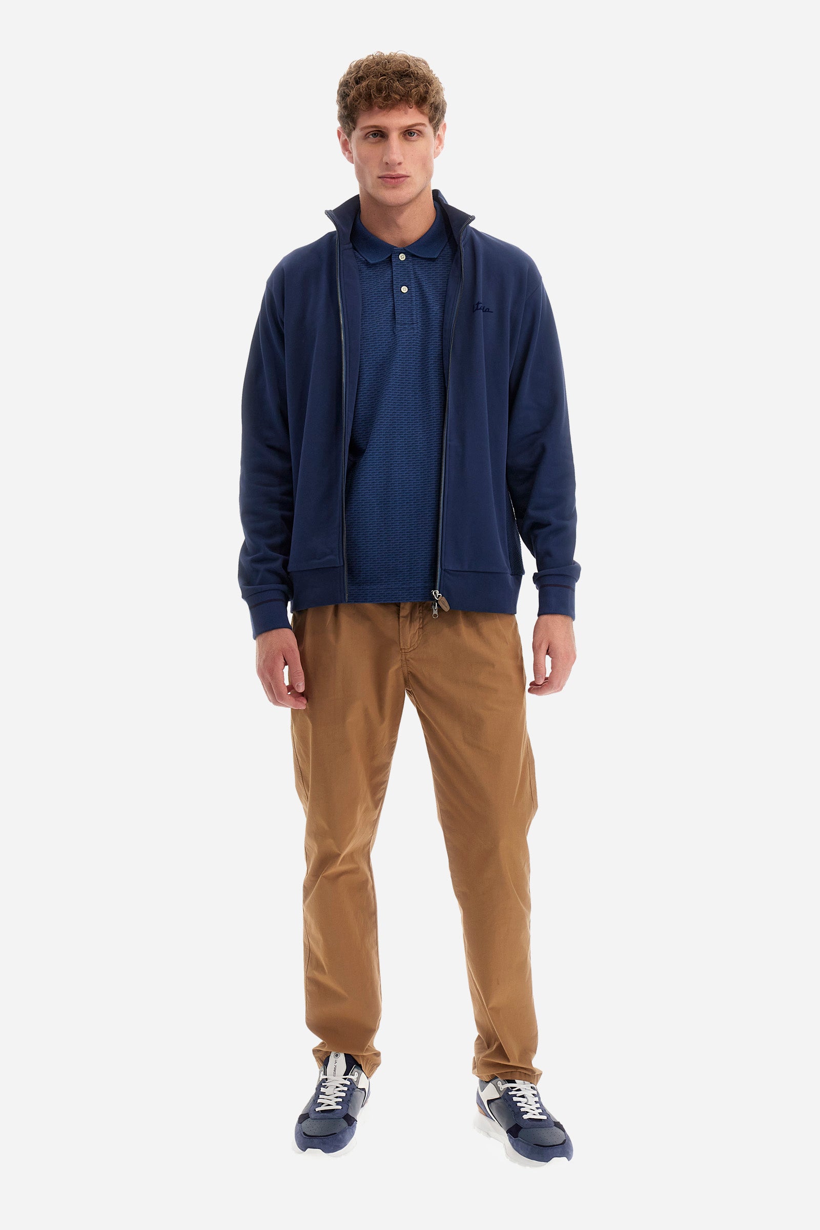 Single-colour long-sleeved men's sweatshirt with full zip fastening from the line in collaboration with Pagani. Made of 100% cotton. Mock neck, ribbed waistband and cuffs. Double back pocket. On the sides the garment has a different texture from the main part. There is lettering on the front, while a plate featuring the La Martina logo and the Pagani logo is sewn on the back. The fit is regular. The model wears a size L. - Ensign Blue