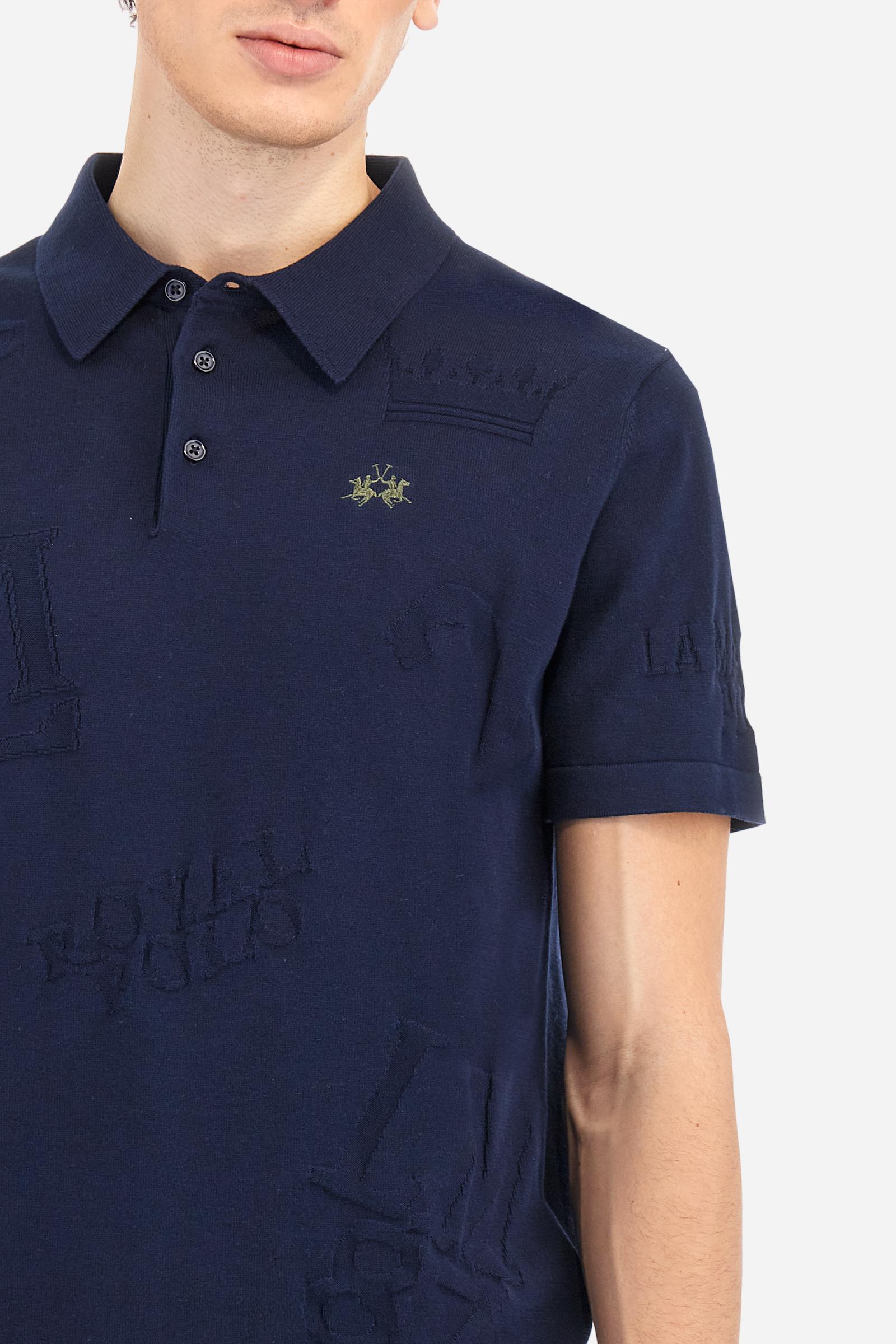 Men's short-sleeved, single-colour knitted polo shirt made of 100% combed cotton yarn. The fastening is with three buttons and the inside of the opening is in vertical rib. Various graphics are present over the garment, made by machine using an inlay technique. The logo on the left side of the chest is embroidered tone on tone. Regular fit. The model is wearing a size L. - Navy