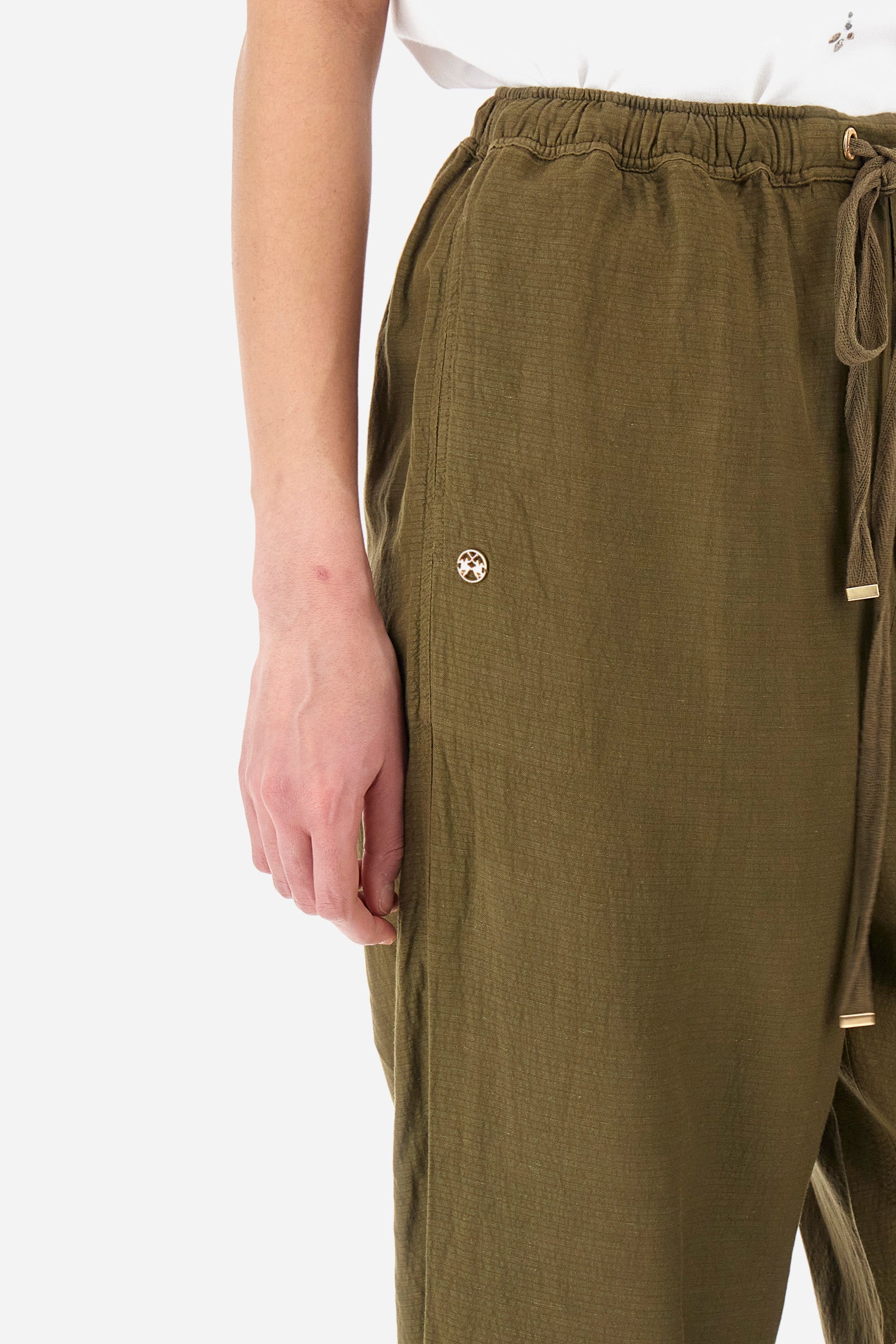 Women’s trousers in solid color, made of oxford fabric. Drawstring waist along with laces to comfortably adjust the closure. Two front pockets and two back welt pockets. The logo is applied on the back and on a metal plate sewn into the front. The fit is regular. The model wears a size 2. - Military Olive
