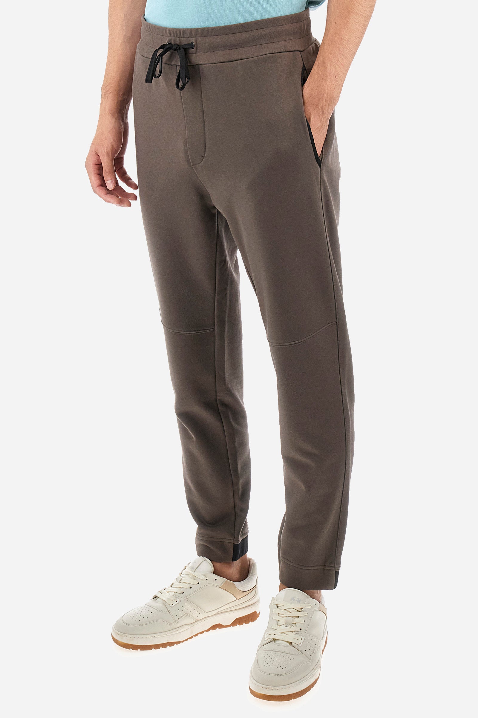 Men's single-colour jogging bottoms in a cotton sweat fabric. With a drawstring waist and double front pocket. With different shades at the bottom of the leg. On the back there is a pocket with a zip fastening featuring contrasting textures and colours. The logo is present on the tag sewn on the back pocket. The fit is regular. The model wears a size L. - Bungee Cord