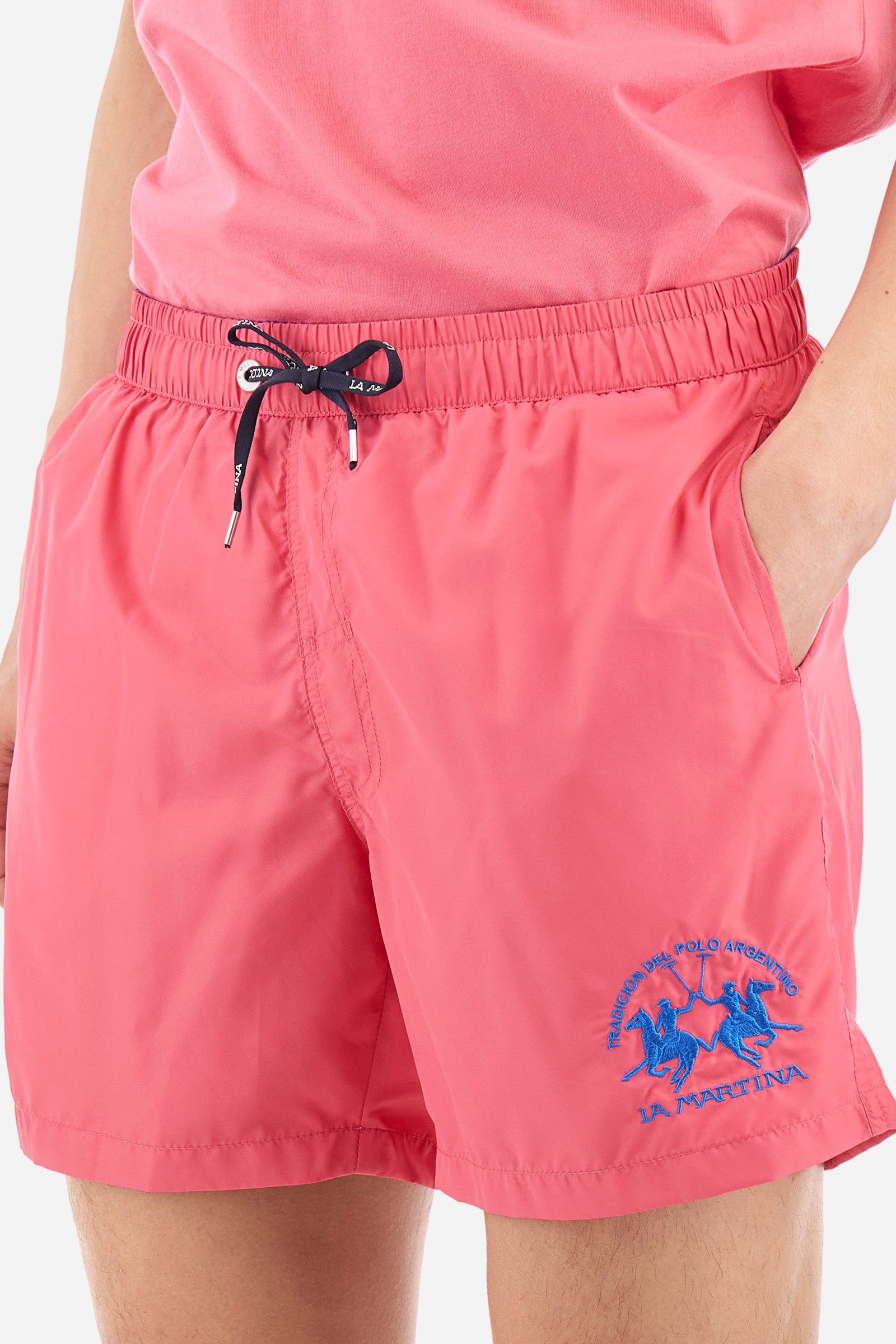 Single-colour men's swimming shorts, made of synthetic fabric. Featuring a drawstring and tie with "La Martina" lettering. Double welt pocket on the front. Closed pocket on the back. Mesh lining. Large logo embroidered on the front. The fit is regular. The model wears a size L. - Hot Pink