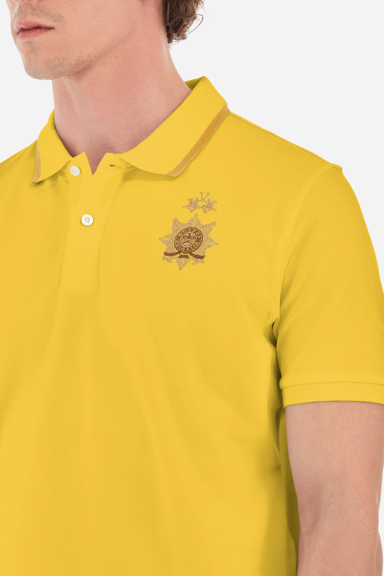 Men's short-sleeved single-colour polo shirt in elasticated cotton. Two-button fastening. Ribbed collar and armholes. The neck is profiled. On the front we find the symbol representing the Guards line. Featuring a small logo embroidered on the chest. The fit is regular. The model wears a size L. - Aspen Gold