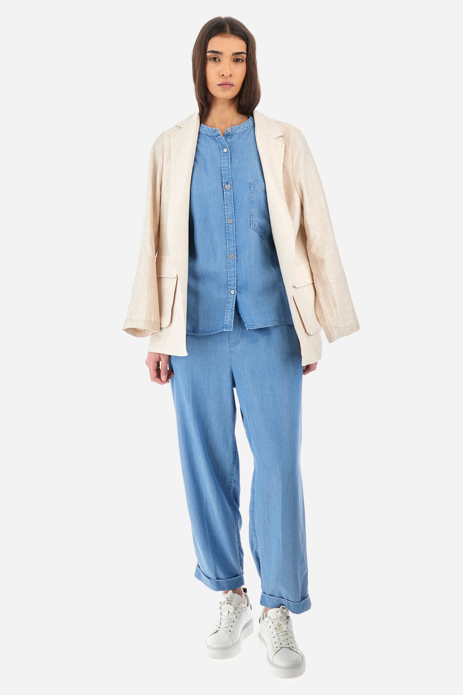 Women’s trousers in solid color, made of ecological lyocell denim fabric. Drawstring waist and laces to adjust the closure comfortably. Two front and two back pockets, all flush. The logo is present on a patch sewn on the back and on a metal plate on the front. The fit is regular. The model wears a size 2. - Medium Indigo Denim