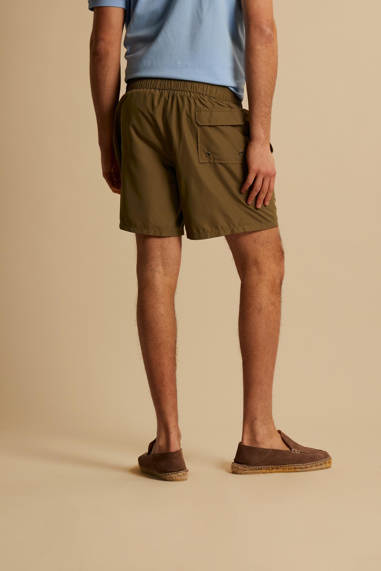 Men’s solid nylon mid-length swim shorts. Regular fit with elasticated waistband, adjustable drawstring, back pocket and embroidered logo. - Burnt Olive