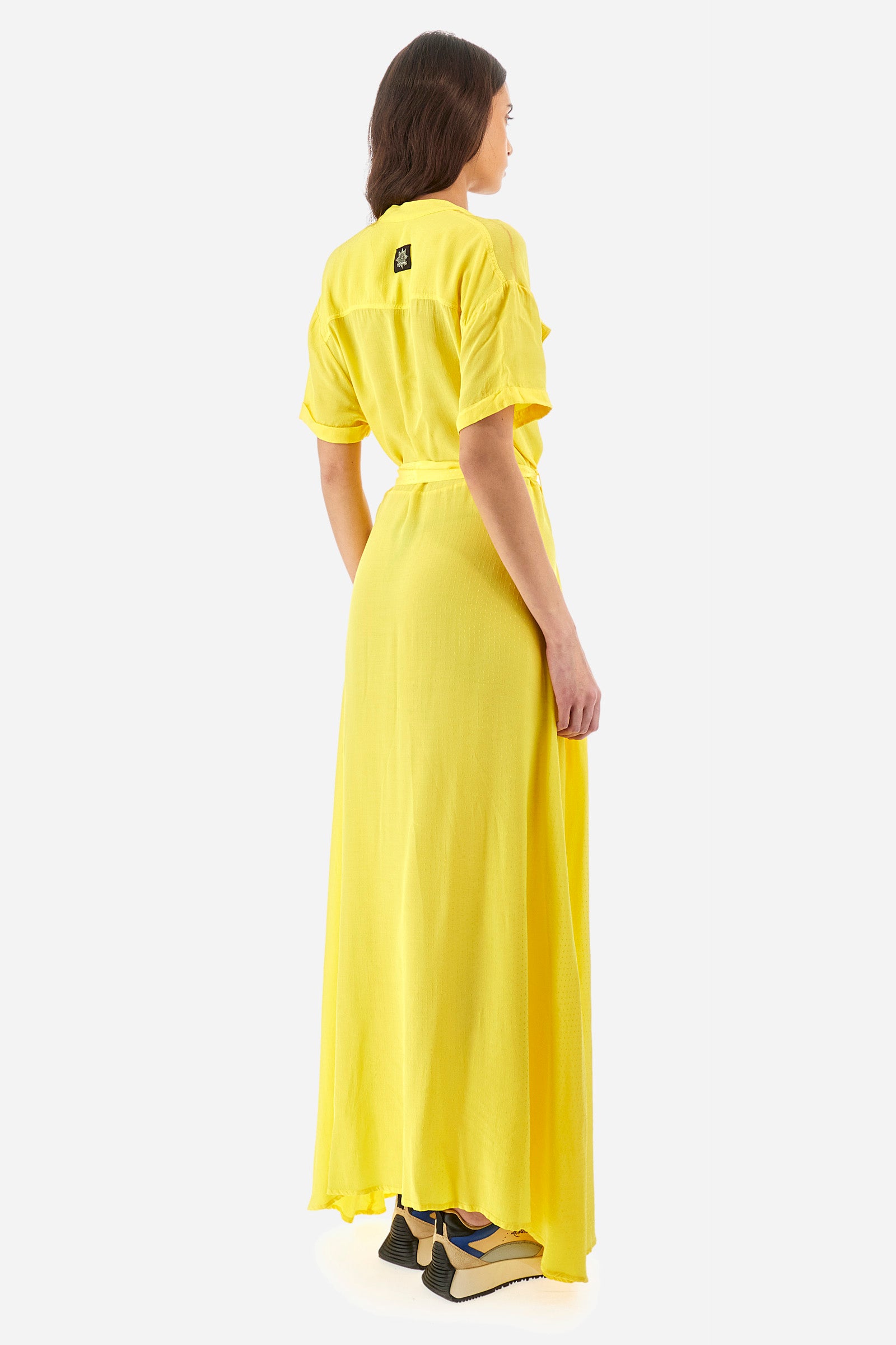 Women’s dress with short sleeves in solid color with bright tone on tone details. Made of synthetic viscose satin fabric. Silhouette straight cut and soft, long to the feet. Waist marked by the belt supplied with the head. V-neck and stand-up collar. Closure with buttons that reach up to the end of the dress. Presence of two fake pockets with buttons on the chest. The patch applied on the back with the representative symbol of the Guards line. The fit is regular. The model wears an IT40 size. - Aspen Gold