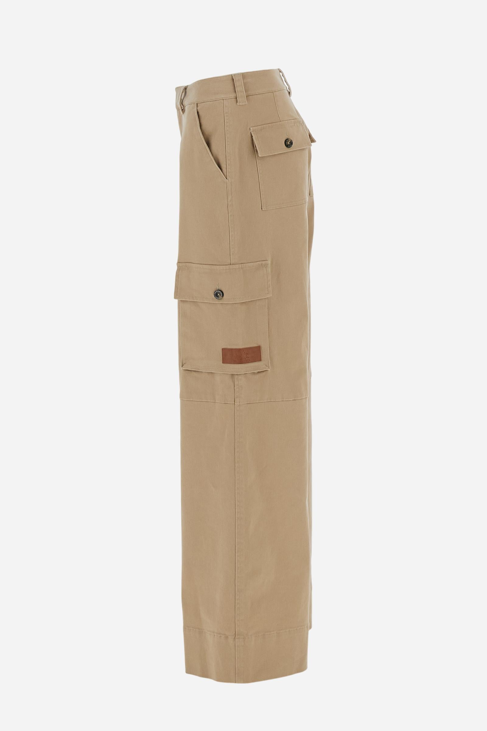 Women’s long cargo trousers in stretch cotton twill with front zip and internal hook closure. Side slash pockets and large applied thigh pockets with flap and personalised horn-effect buttons, also repeated on the back as a detail. Logo on faux leather label applied to the left thigh pocket. Relaxed fit with wide, straight leg. The model wears size 2. - Travertine