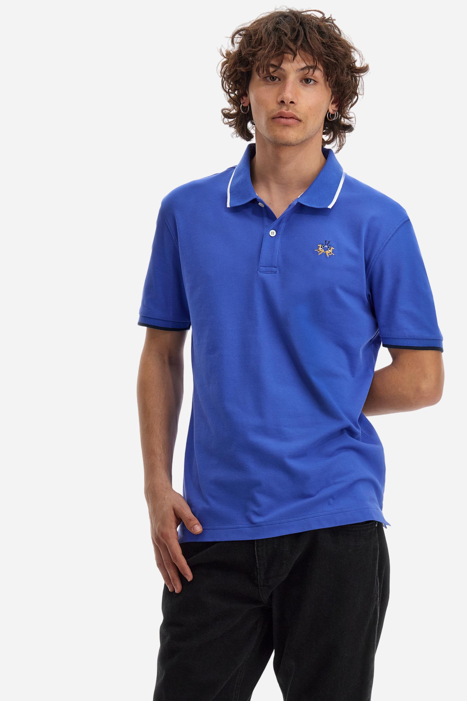 Short-sleeved, single-colour men's polo shirt made of stretch cotton piqué. Fastens with two buttons. The collar and cuffs are ribbed, and there is a colour-contrasting trim at the bottom of the collar. Inside the collar there is a grosgrain ribbon of a different shade. The logo is embroidered on the chest in a contrasting colour. The fit is slim. The model is wearing a size L. - Dazzling Blue