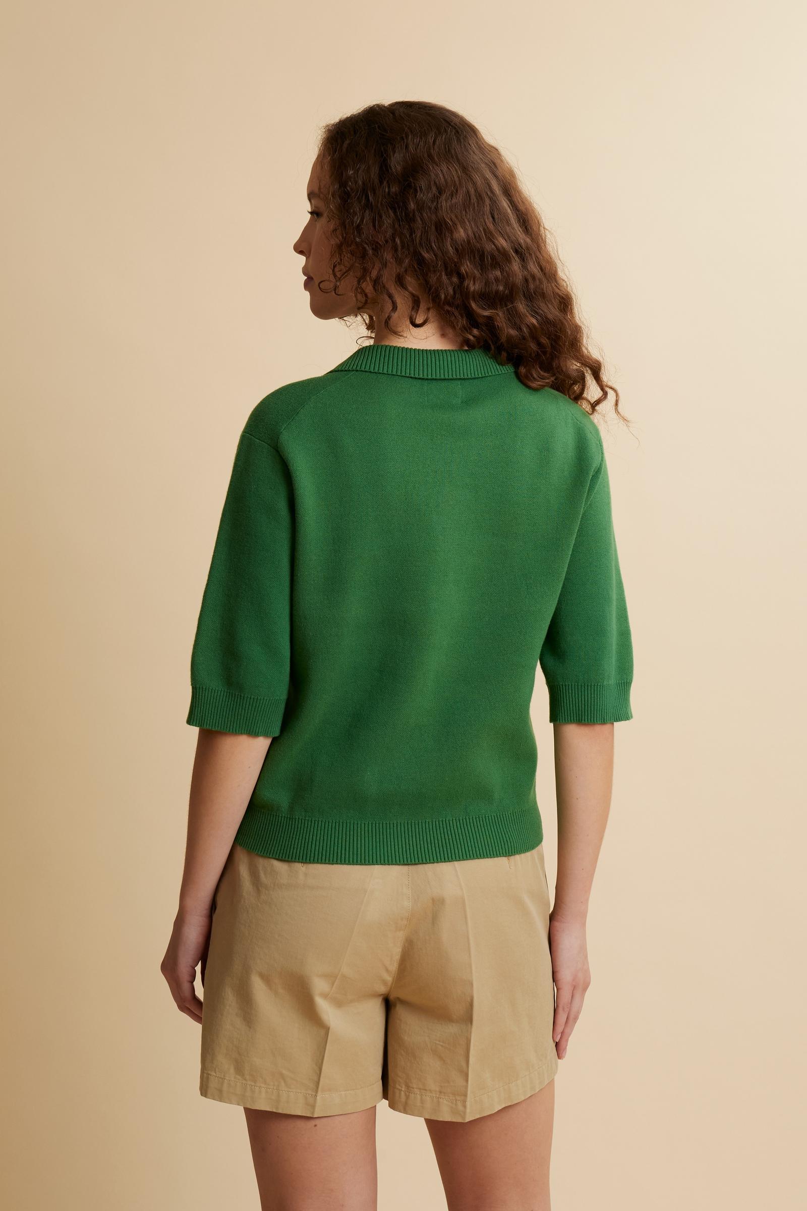 Women’s short-sleeve knit polo in compact structured cotton. Ribbed collar with V-neckline without buttons for a feminine touch. Defined silhouette and slightly cropped length. Large front intarsia logo integrated into the knit for a smooth refined finish. The model wears size 2. - Amazon