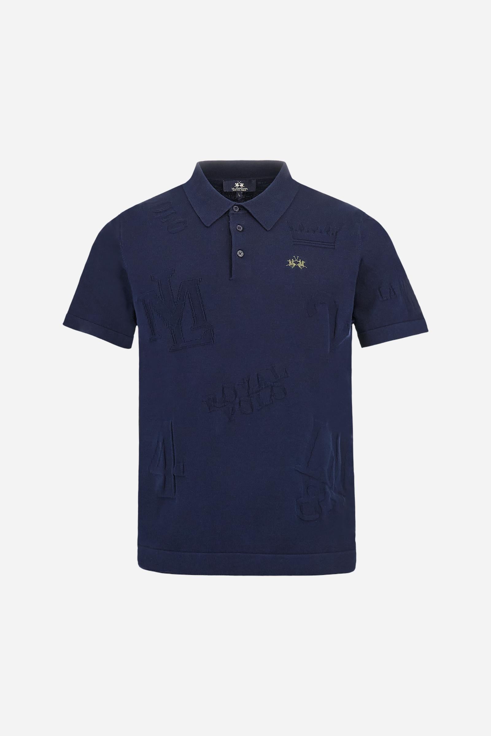 Men's short-sleeved, single-colour knitted polo shirt made of 100% combed cotton yarn. The fastening is with three buttons and the inside of the opening is in vertical rib. Various graphics are present over the garment, made by machine using an inlay technique. The logo on the left side of the chest is embroidered tone on tone. Regular fit. The model is wearing a size L. - Navy