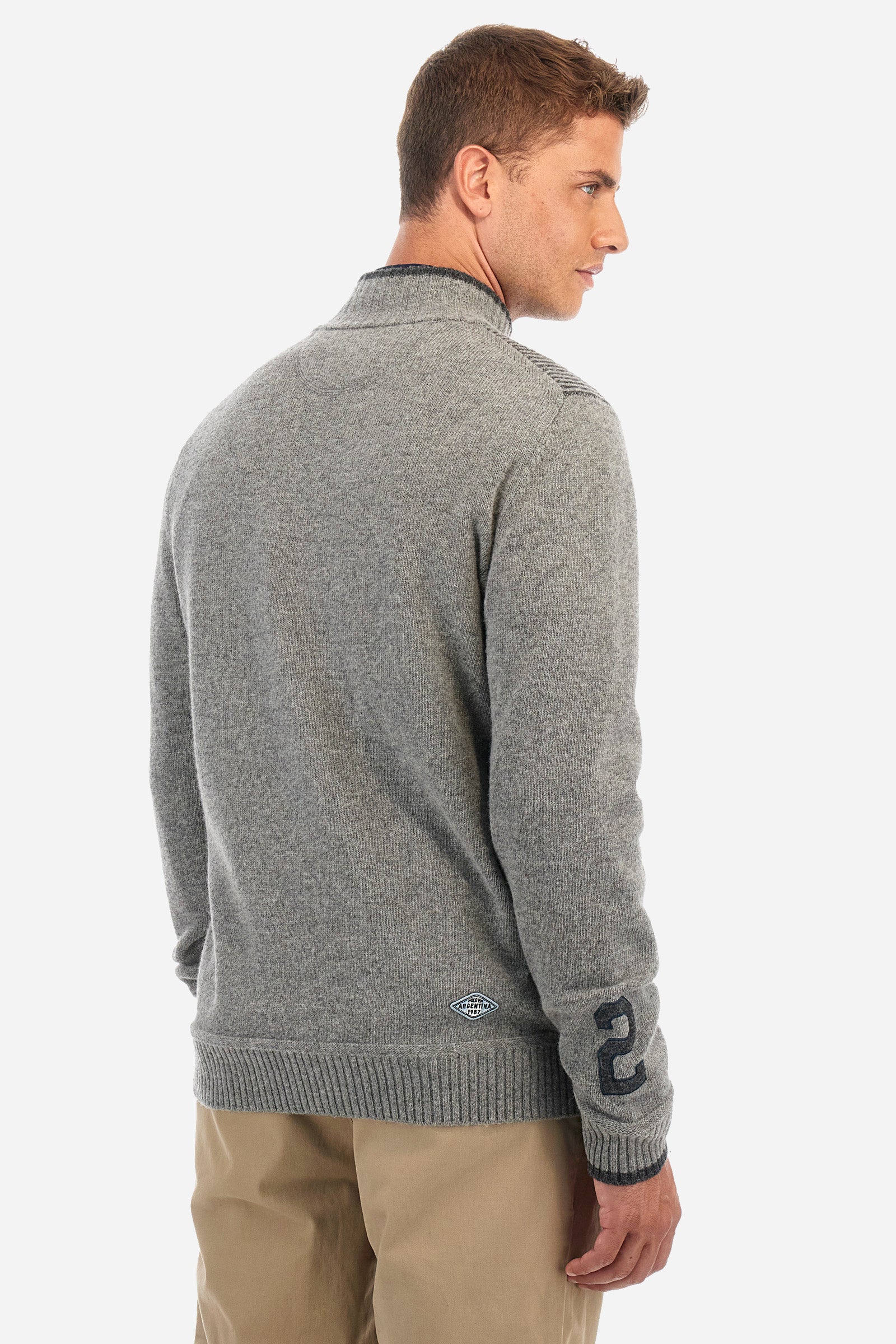 Men's long-sleeved plain pullover with a full-zip fastening, made from a wool blend. Mock polo neck. Ribbed shoulders, cuffs, hem and collar. Patch on one of the sleeves. The logo appears on the front with a patch representing the Argentina line. Regular fit. The model is wearing a size L. - Medium Heather Grey