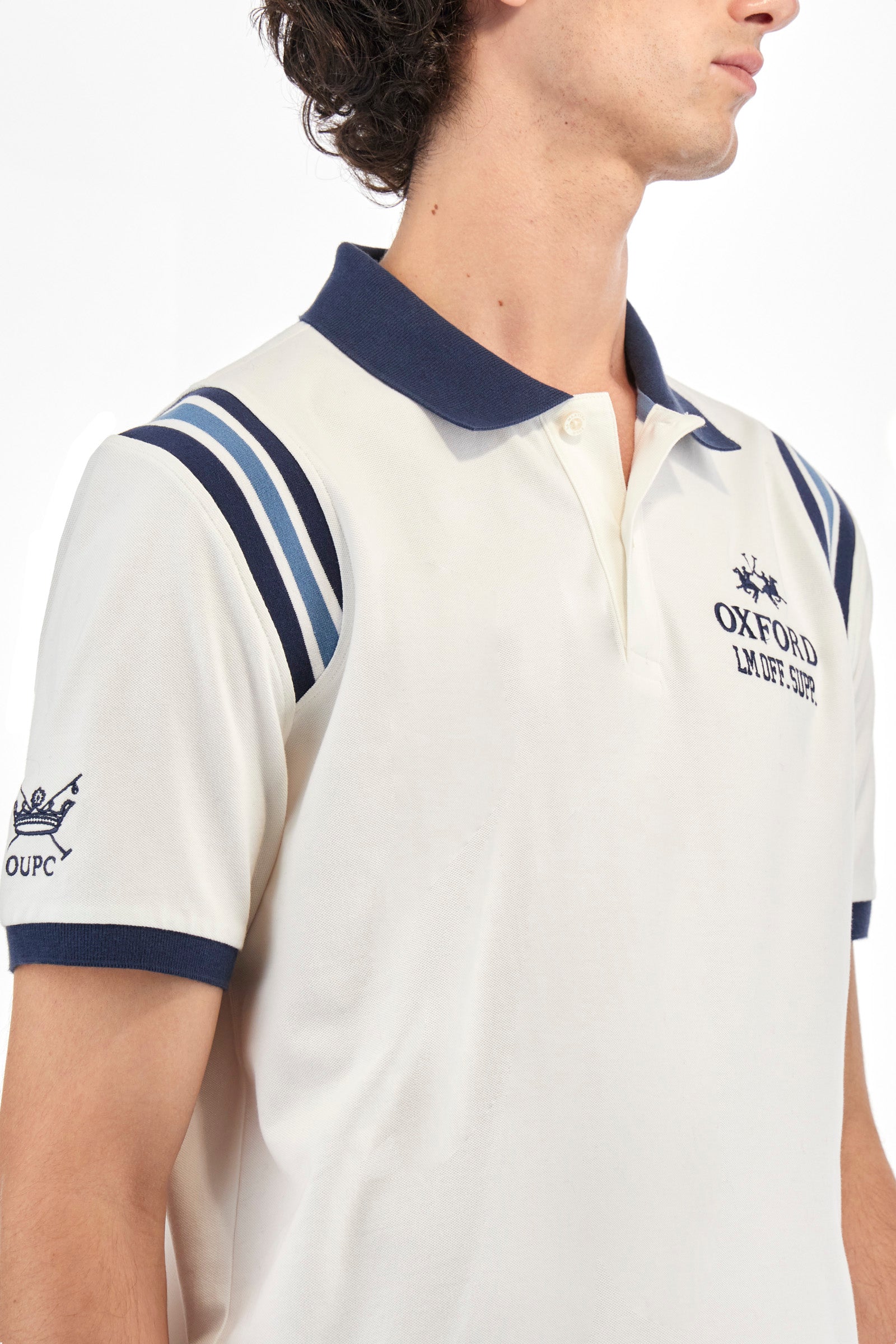 Men's short-sleeved polo shirt in plain stretch cotton. Two-button fastening. The sleeves are finished with contrasting stripes. The logo and lettering associated with the Oxford line are embroidered on the front. Regular fit. The model is wearing a size L. - Off White