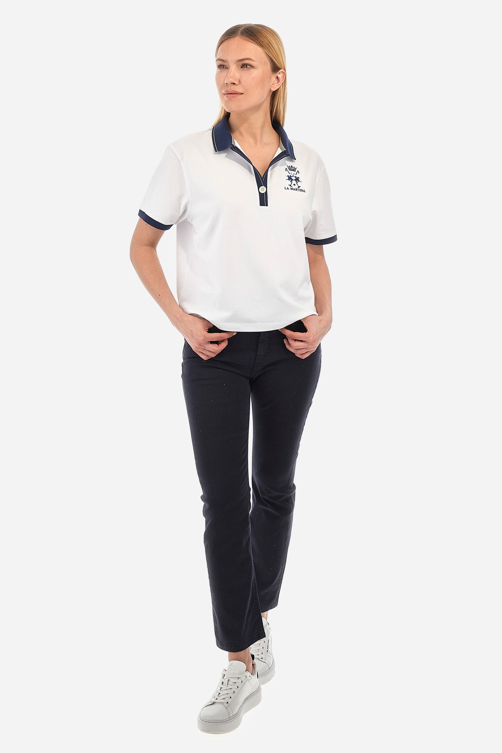 Women’s polo with short sleeves in solid color with contrasting details of the Academy Polo line. Made of stretch cotton. V-neck and armhole hem in contrasting shades. Single button closure. Ribbed neckline, collar and armhole. On the back is sewn the name and logo of the brand. On the back there is a metal plate with the logo applied on a colored strip. The fit is regular. The model wears a size 2. - Optic White