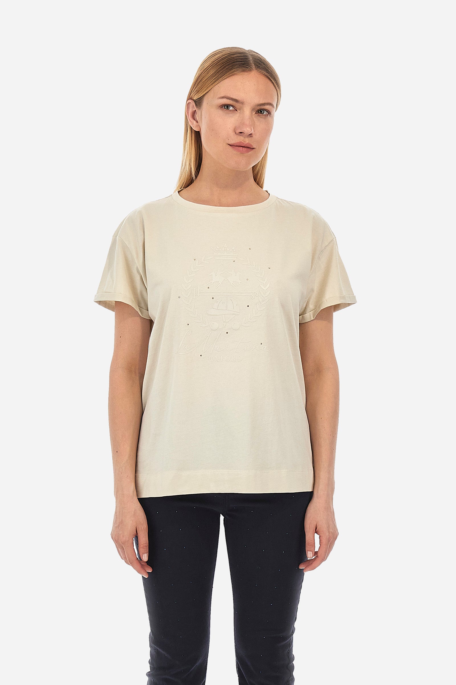 Women's short-sleeved T-shirt with a crew neck in a single colour from the Polo Academy line. Made of 100% cotton. There is a slight turn-up on the sleeve. The front features the La Martina logo and lettering and some of the symbols of the Polo Academy line, all tone on tone. The T-shirt is embellished with all-over tone-on-tone rhinestone applications. The fit is regular. The model wears a size 2. - Bone White