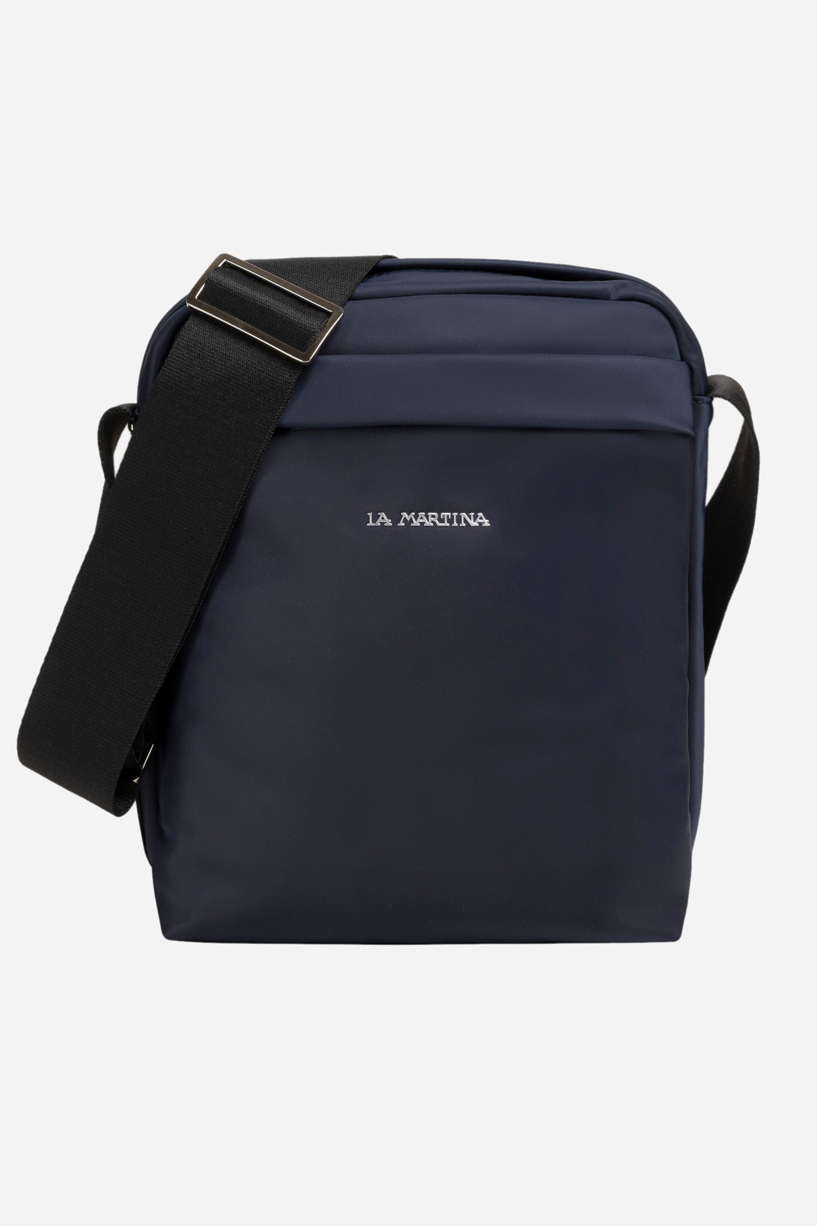 Single-colour men's crossbody bag in nylon with polyurethane details With zip fastening. There are two additional external pockets, one with a zip fastening and one with a magnetic button. Adjustable fabric shoulder strap. On the back is another pocket with a pneumatic closure. The inside features two pockets: one open pocket and one with a zip. The lettering "La Martina" is positioned on the front in metal. Dimensions (length x height x width) 21 x 26 x 7 cm. - Navy