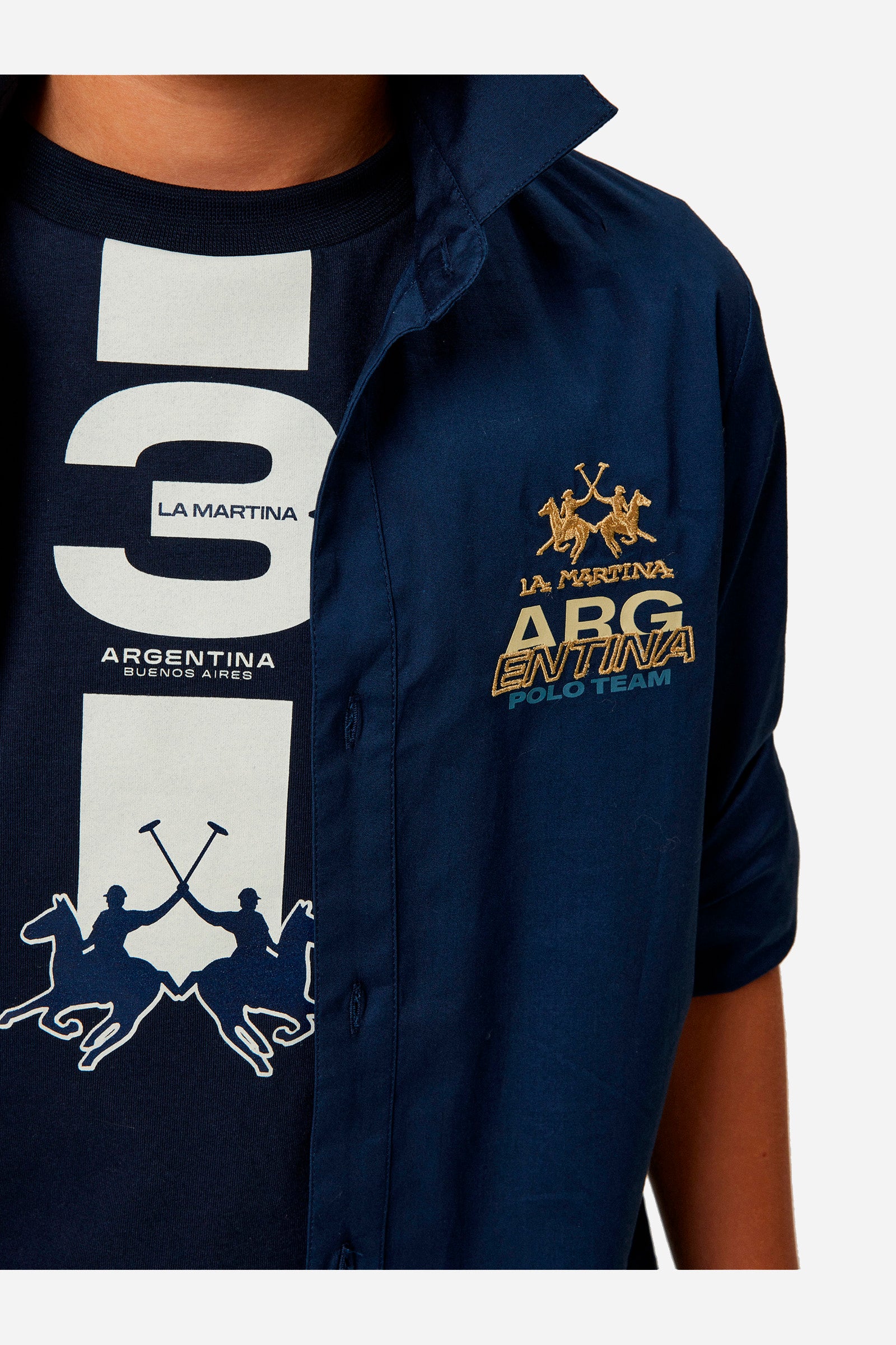 Single-colour boys' shirt made of cotton poplin. Pointed collar. Regular line. On the back there is a large rubberised print. The logo is on the chest, left side. - Navy