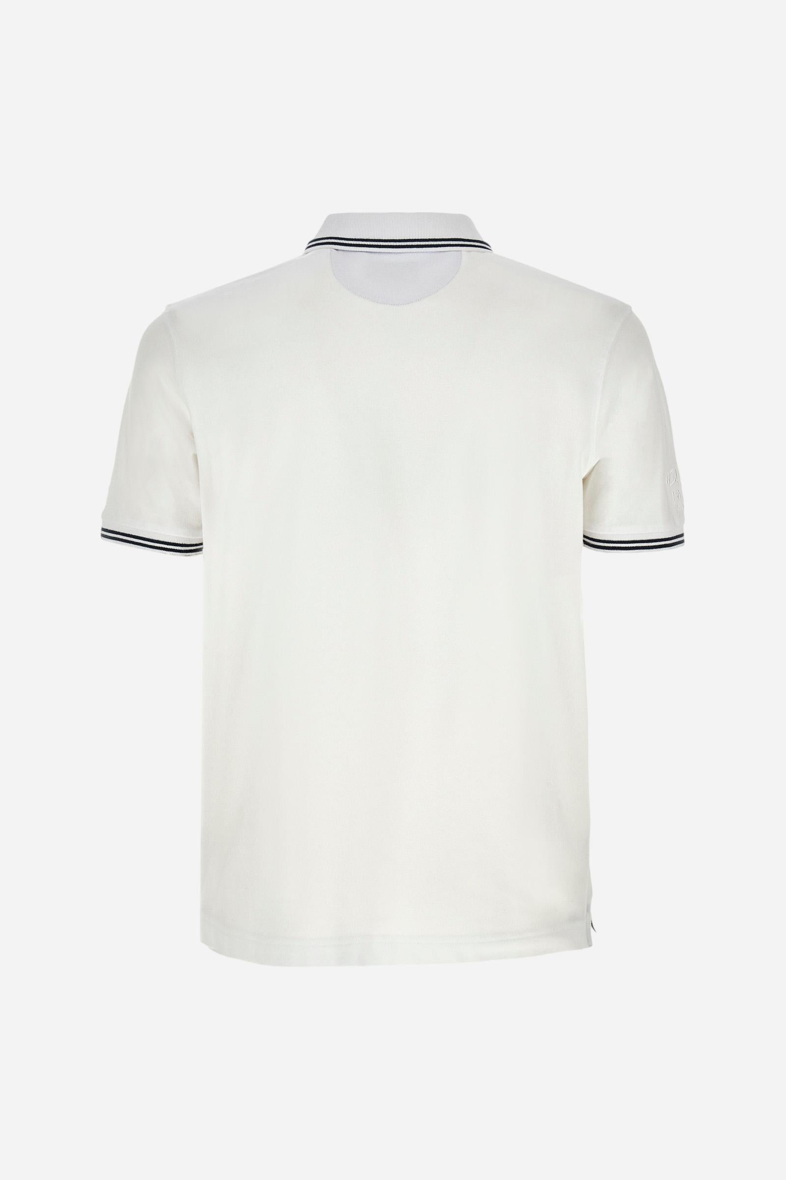 Men's plain short-sleeved polo shirt made from stretch piqué. Two-button fastening. The collar and cuffs are made from two-tone striped ribbed fabric. The inside of the collar and placket feature contrasting fabrics and colours. There is a two-tone striped band around the inside of the collar. The right sleeve and chest are embroidered in tone-on-tone thread. A logo is embroidered on the left sleeve, also using tone-on-tone thread. Regular fit. The model is wearing a size L. - Optic White