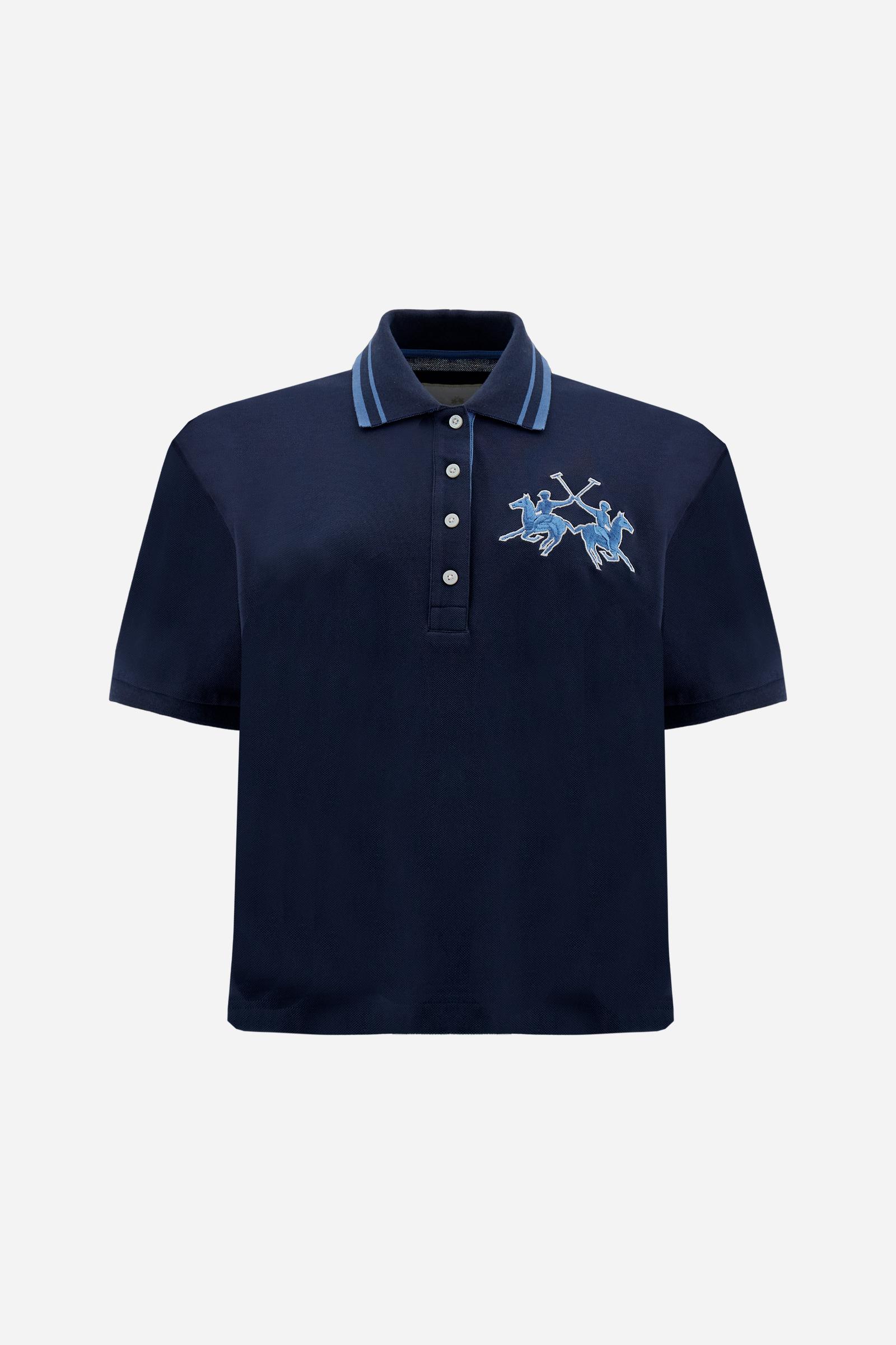 Women's short-sleeve polo shirt made from 100% cotton piqué fabric in solid color. The model features a front opening with customized buttons and a contrasting inner placket. The ribbed collar is two-tone with a striped detail creating a positive/negative color effect between the upper and lower parts. The modern fit features a slightly boxy cropped cut. The chest is decorated with a maxi 3D embroidered logo in contrasting color. The model is wearing size 2. - Navy