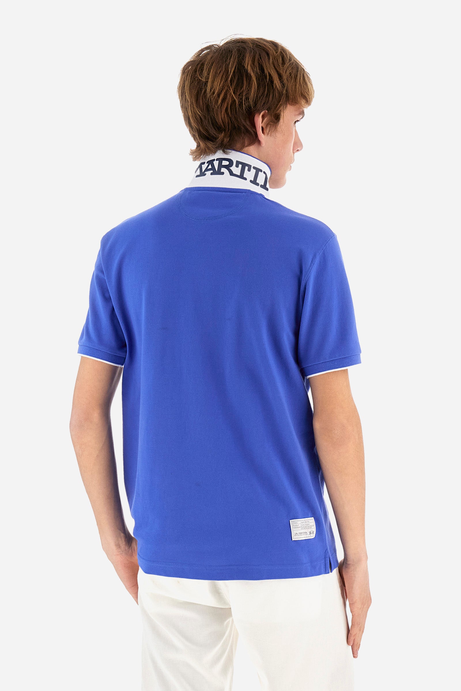 Men's plain short-sleeved polo shirt made from stretch piqué. Featuring a two-button fastening and a ribbon on the inside collar in contrasting coloured grosgrain. The collar and cuffs are in matching rib knit, with the undercollar also in rib knit but in a contrasting colour. The large logo is embroidered on the chest, left side with contrasting coloured thread. The undercollar features a print of the La Martina lettering in a contrasting colour. Regular fit. The model is wearing a size L. - Dazzling Blue