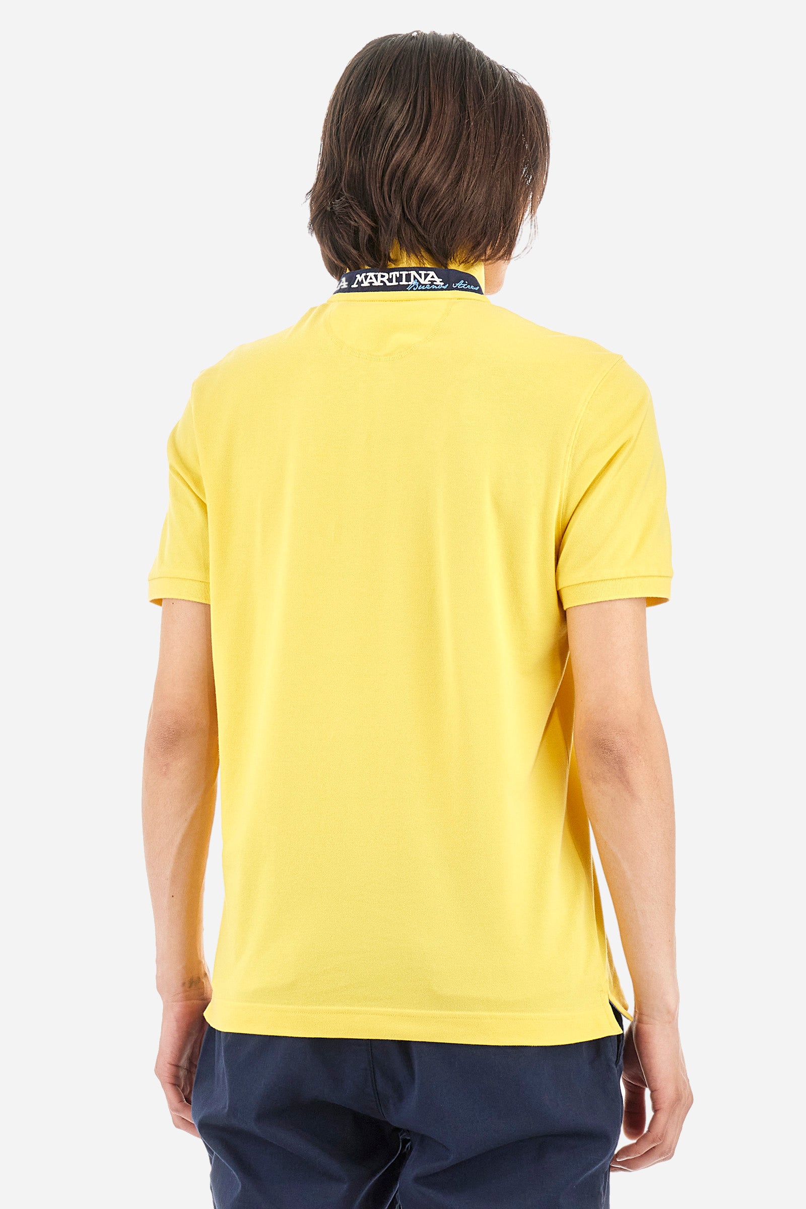 Men's single-colour short-sleeved polo in elasticated cotton. Two-button fastening. Tone-on-tone stitching. Ribbed collar and armholes. The "La Martina" lettering can be found under the collar. Featuring a small logo embroidered on the chest. In a slim fit. The model wears a size L. - Aspen Gold