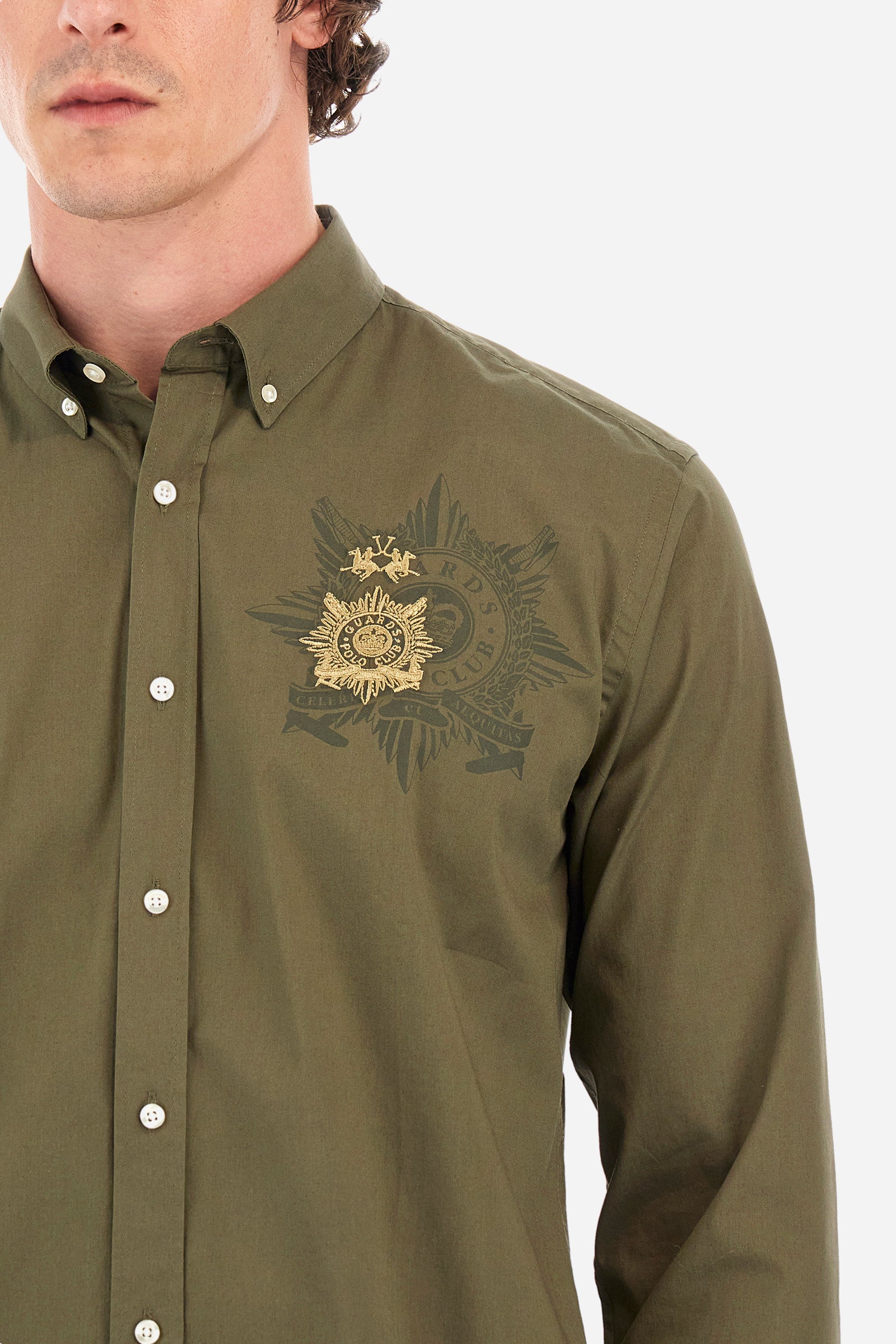 Men's single-colour long-sleeved shirt in elasticated cotton. Button-down collar. With buttoned cuffs. A small logo and the Guards line symbol are embroidered on the front. The fit is regular. The model wears a size L. - Military Olive