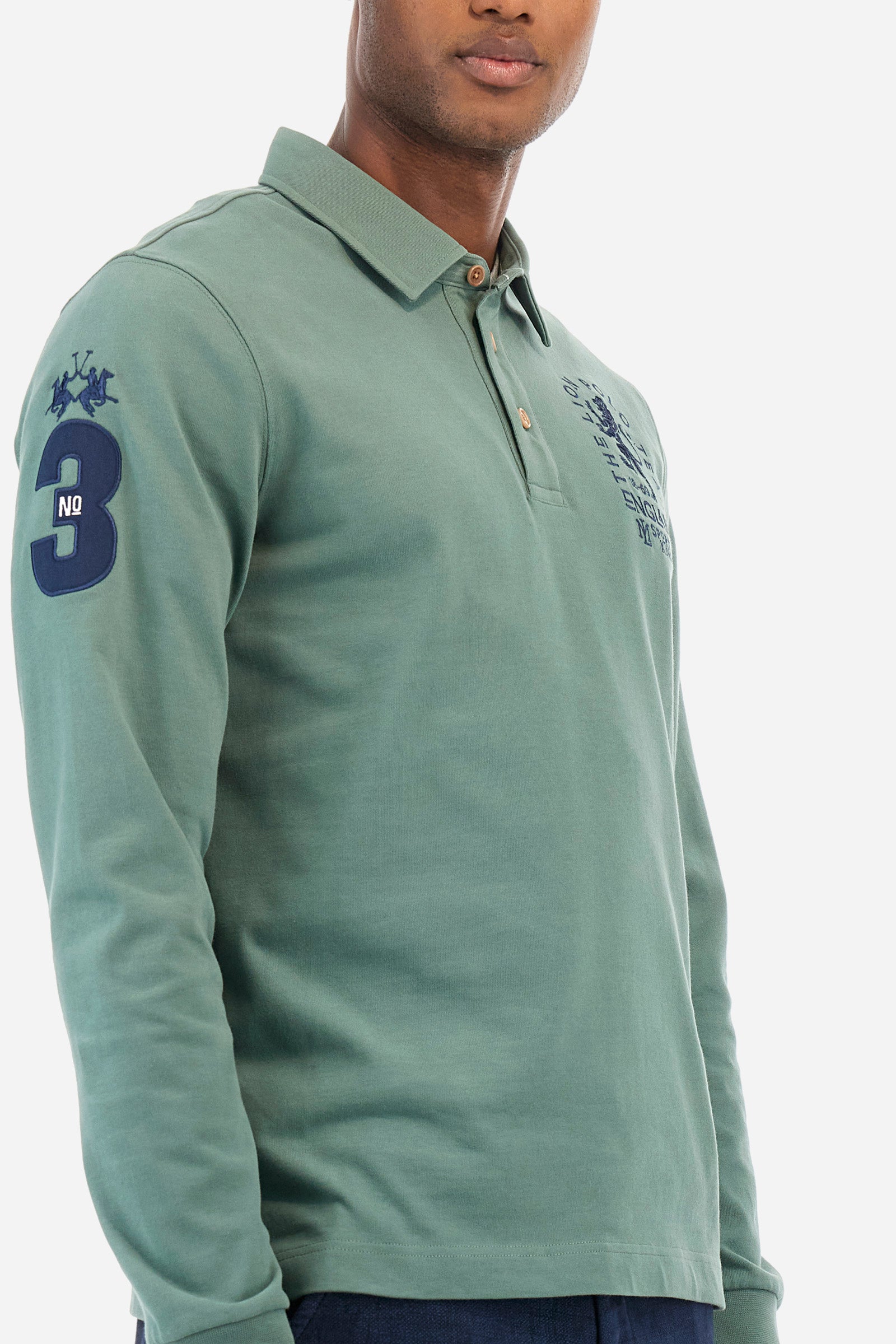 Men's plain short-sleeved polo shirt, made from 100% cotton. Three-button fastening. One of the sleeves features a patch depicting the number 3 and the brand logo. The front is finished with symbols and lettering associated with the England line. Regular fit. The model is wearing a size L. - Laurel Wreath