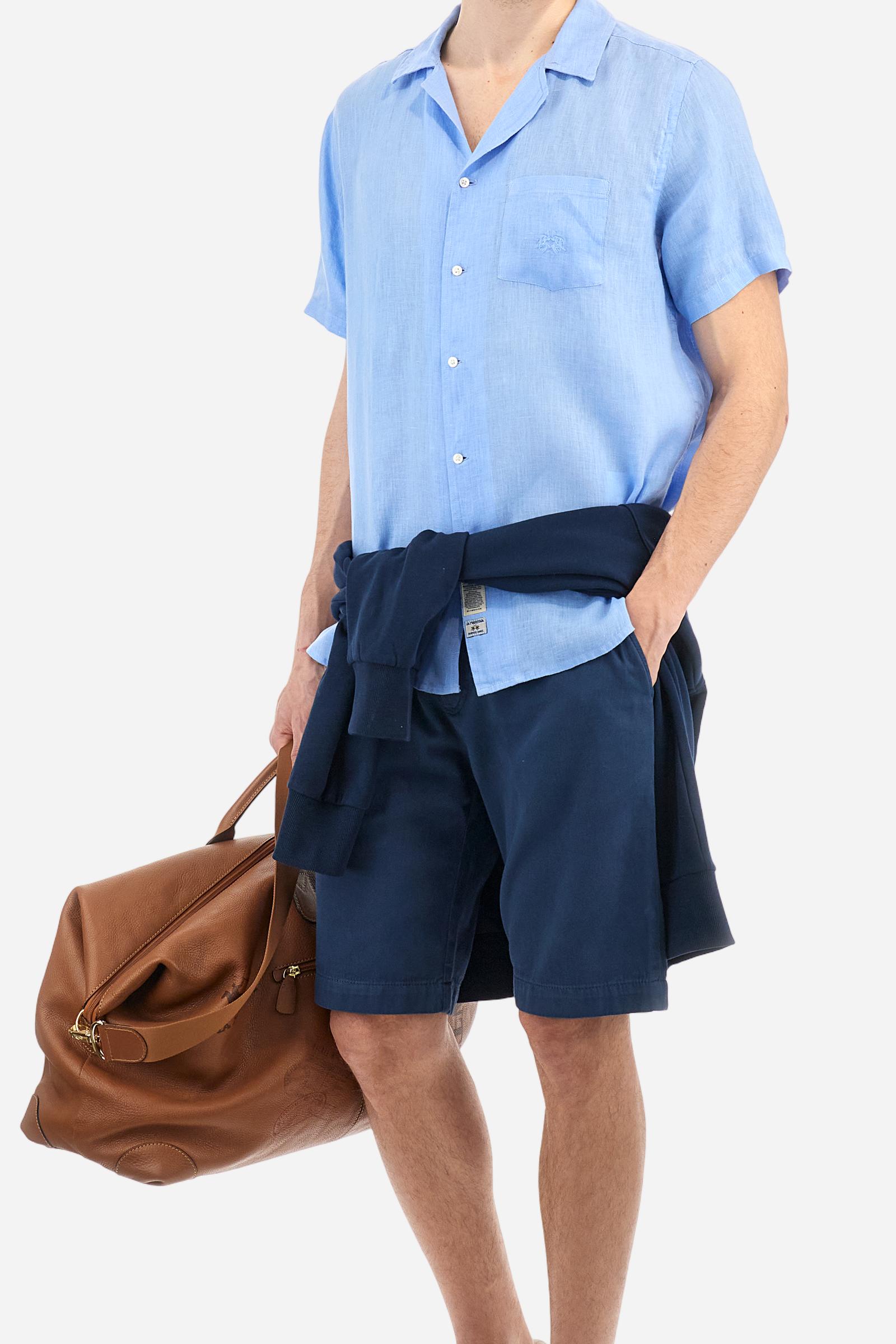 Men's plain short-sleeved shirt made from soft linen canvas. This model features a bowling collar and an appliquéd patch pocket on the left side of the chest, topped with a tone-on-tone embroidered logo. Regular fit. The model is wearing a size L. - Vista Blue
