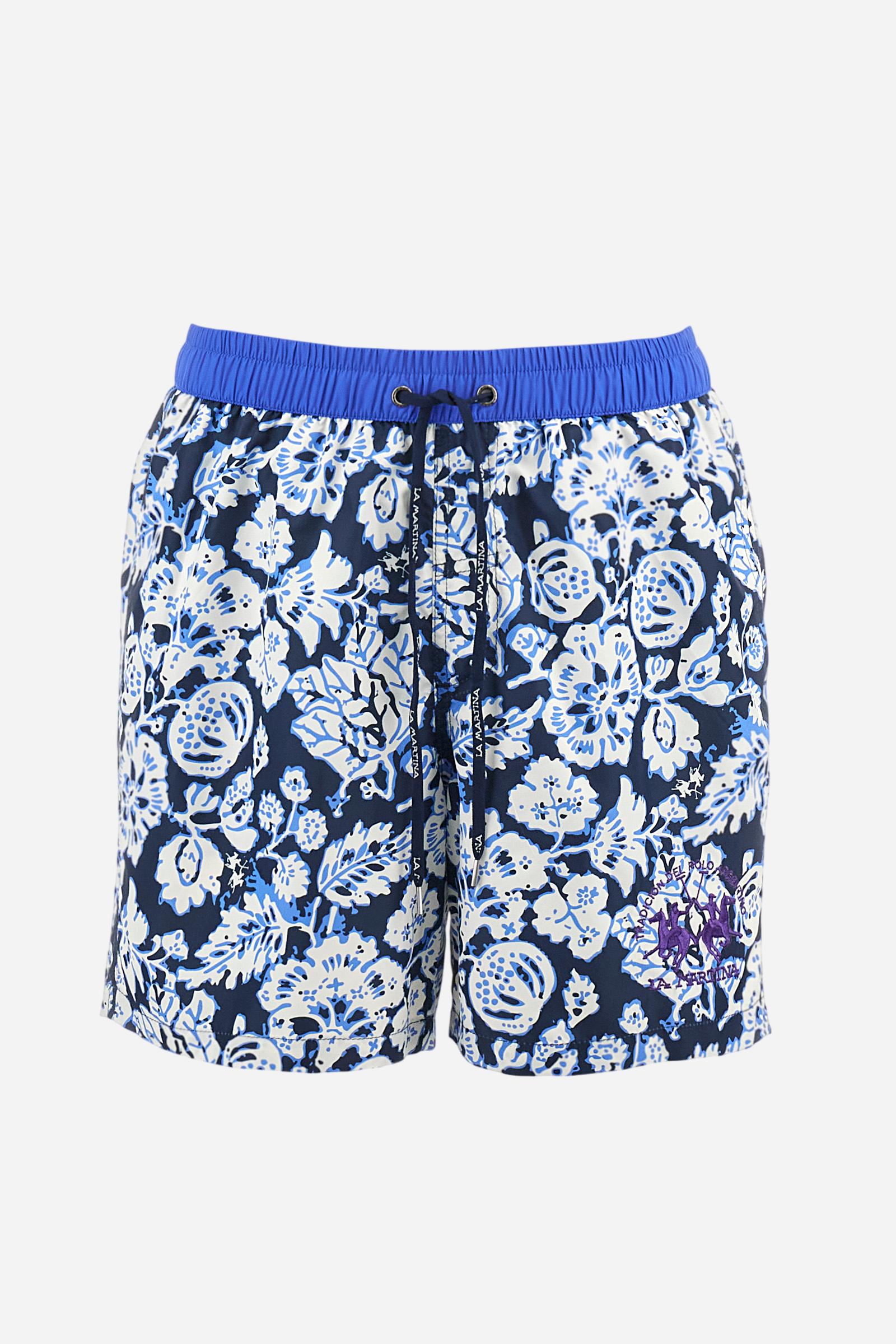 Men's swimming shorts, made of printed nylon. The stylised floral pattern is an exclusive design. The plain nylon elastic waistband has a custom drawstring inside for waist adjustment. On the inside of the shorts is an elasticated mesh brief. Featuring double side pockets on the hips and patch pocket with contrasting coloured flap on the back. The large logo is embroidered on the bottom of the left leg, on the front. Regular fit. The model is wearing a size L. - Navy/Dazzling Blue