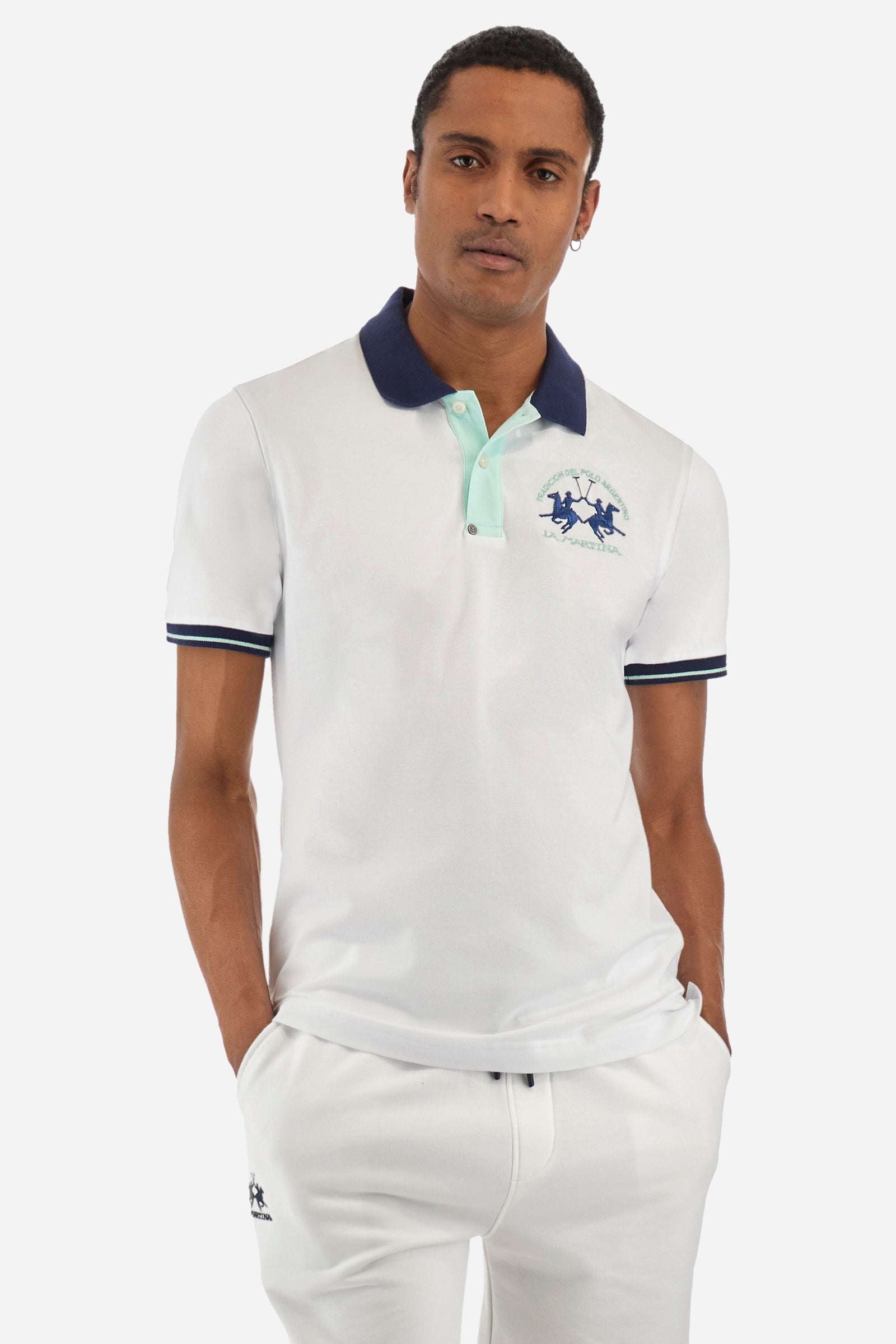 Men's single-colour short-sleeved polo in elasticated cotton. Fastens with two contrasting buttons. Ribbed collar and armholes in different shades. The "La Martina" lettering can be found under the collar. A large logo is embroidered on the chest. The fit is slim. The model wears a size L. - Optic White