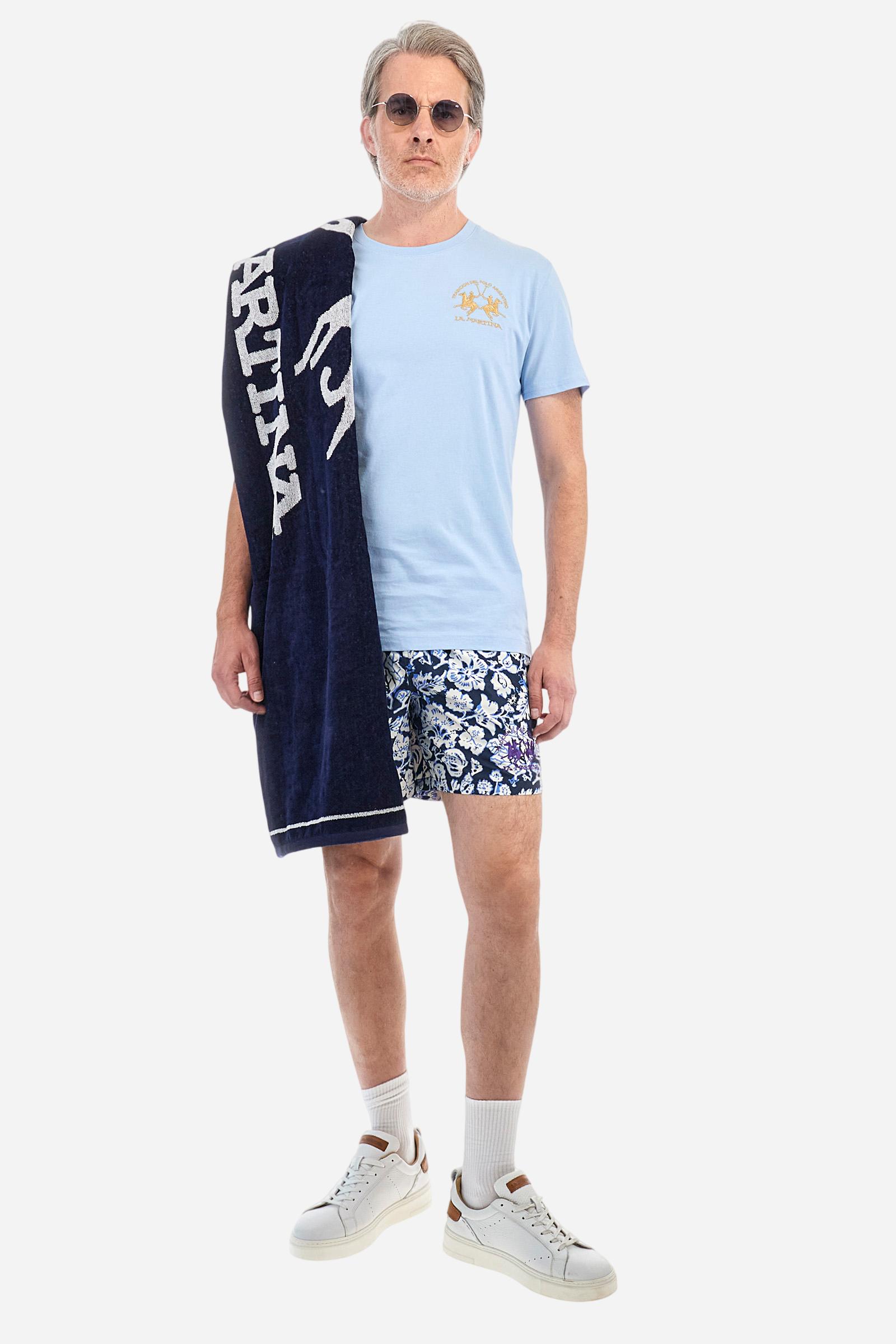 Men's swimming shorts, made of printed nylon. The stylised floral pattern is an exclusive design. The plain nylon elastic waistband has a custom drawstring inside for waist adjustment. On the inside of the shorts is an elasticated mesh brief. Featuring double side pockets on the hips and patch pocket with contrasting coloured flap on the back. The large logo is embroidered on the bottom of the left leg, on the front. Regular fit. The model is wearing a size L. - Navy/Dazzling Blue