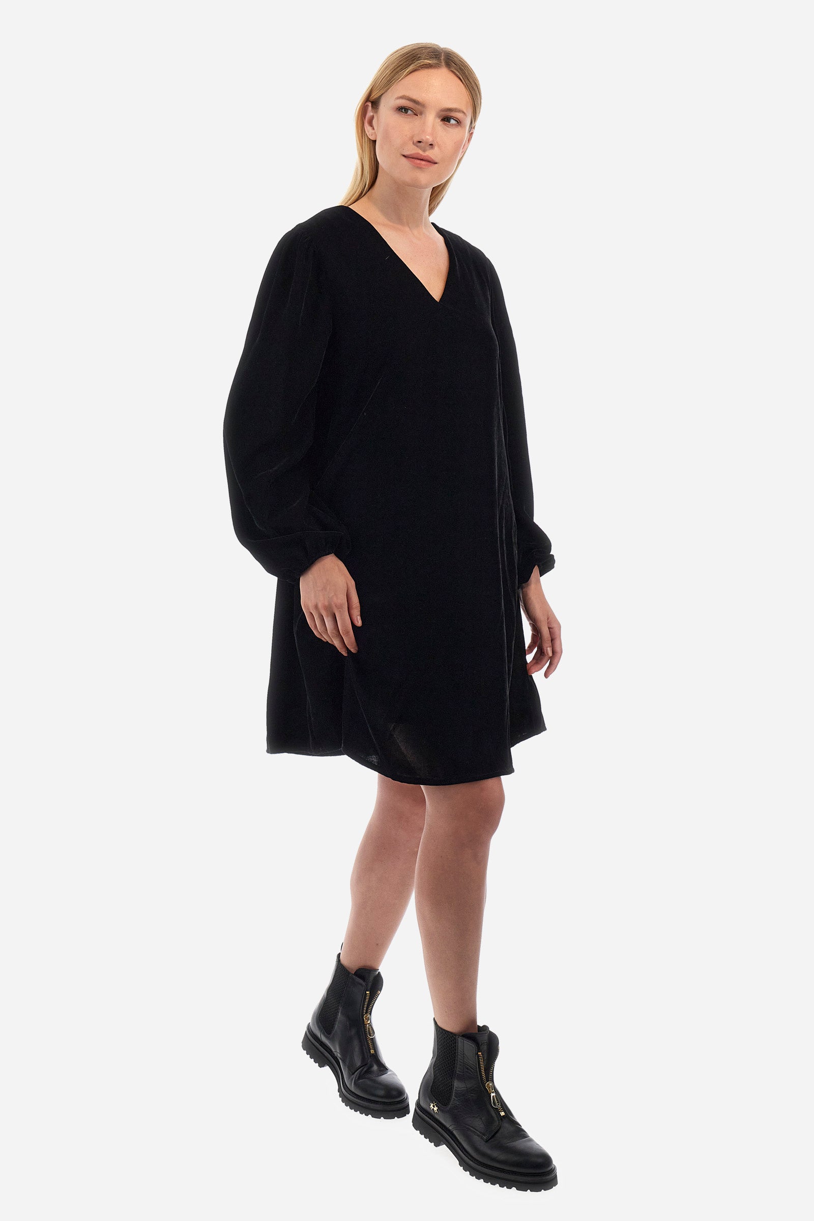 Women's knee-length dress with long sleeves and V-neck on both the front and back. It is made of velvet-effect polyester in a solid colour and features a regular fit, following the England line. The cuff has an elastic band and the side pockets add practicality to the dress. In addition, there is a crown patch logo at the bottom of the dress. Suitable for both the office and more informal occasions. The model is 174 cm tall and wears a size 2. - Black