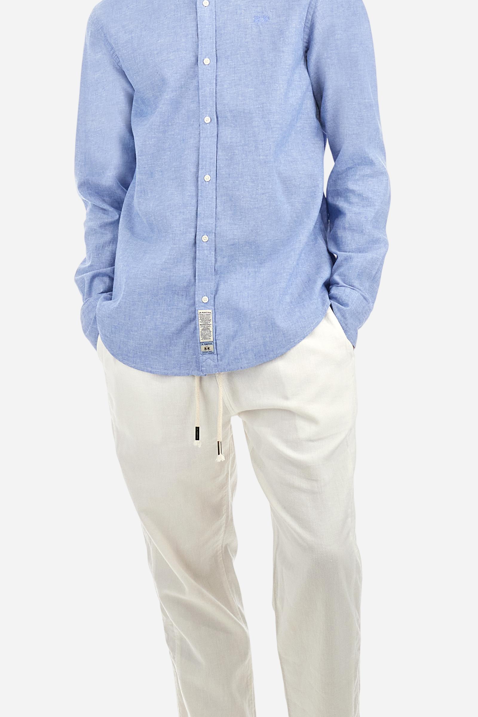 Men's plain long-sleeved shirt made from linen canvas. It features a button-down collar and a basic, traditional design, with woven labels at the bottom of the opening. The logo is embroidered on the chest, over the heart, in tone-on-tone thread. Regular fit. The model is wearing a size L. - Cornflower blue