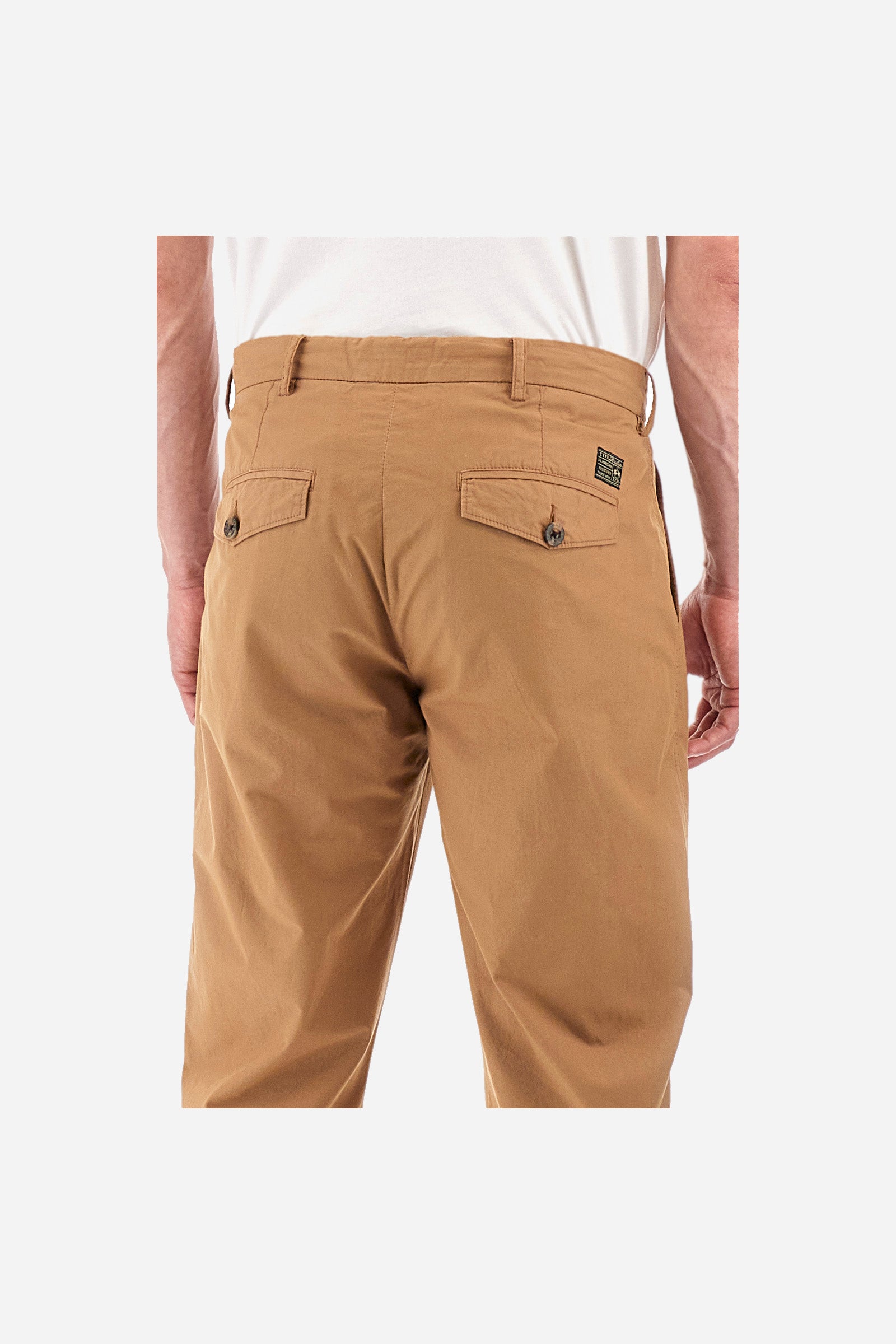 Men's single-colour chinos in 100% cotton. With belt loops, zip and button fastening. Darts on the front. There are two open front pockets and two closed back pockets with a classic button fastening. There is a logo with a patch sewn onto the reverse. The fit is regular. The model wears a size 33. - Tobacco Brown