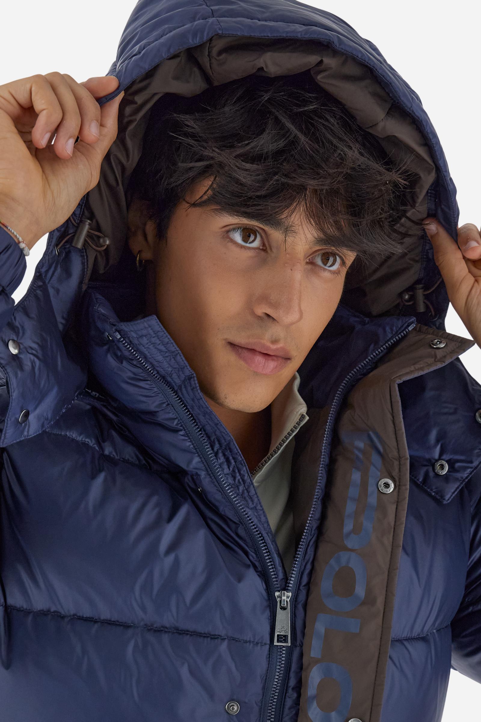 Men’s padded bomber jacket with detachable hood. Made of solid iridescent nylon with contrast lining. Equipped with two practical inner braces for extra comfort. Double customized zip front closure with inner placket featuring contrast Polo Player print, closed with metal snap buttons. Two vertical zipped pockets on the front. Hood with contrast lining and adjustable elastic drawstring. Bold Polo Player graphics printed inside. Regular fit for comfortable movement without bulk. Model wears size L. - Navy