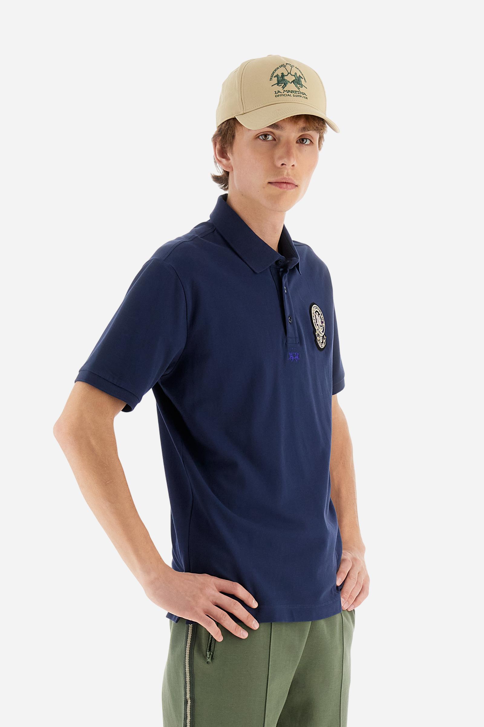 Men's short-sleeved polo shirt in a single colour, made of cotton stretch pique. Fastens with three buttons. Cuffs and collar in rib knit to match the garment. Patch in metallic thread applied on the chest. A colour-contrasting logo is present on the front. Regular fit. The model is wearing a size L. - Navy