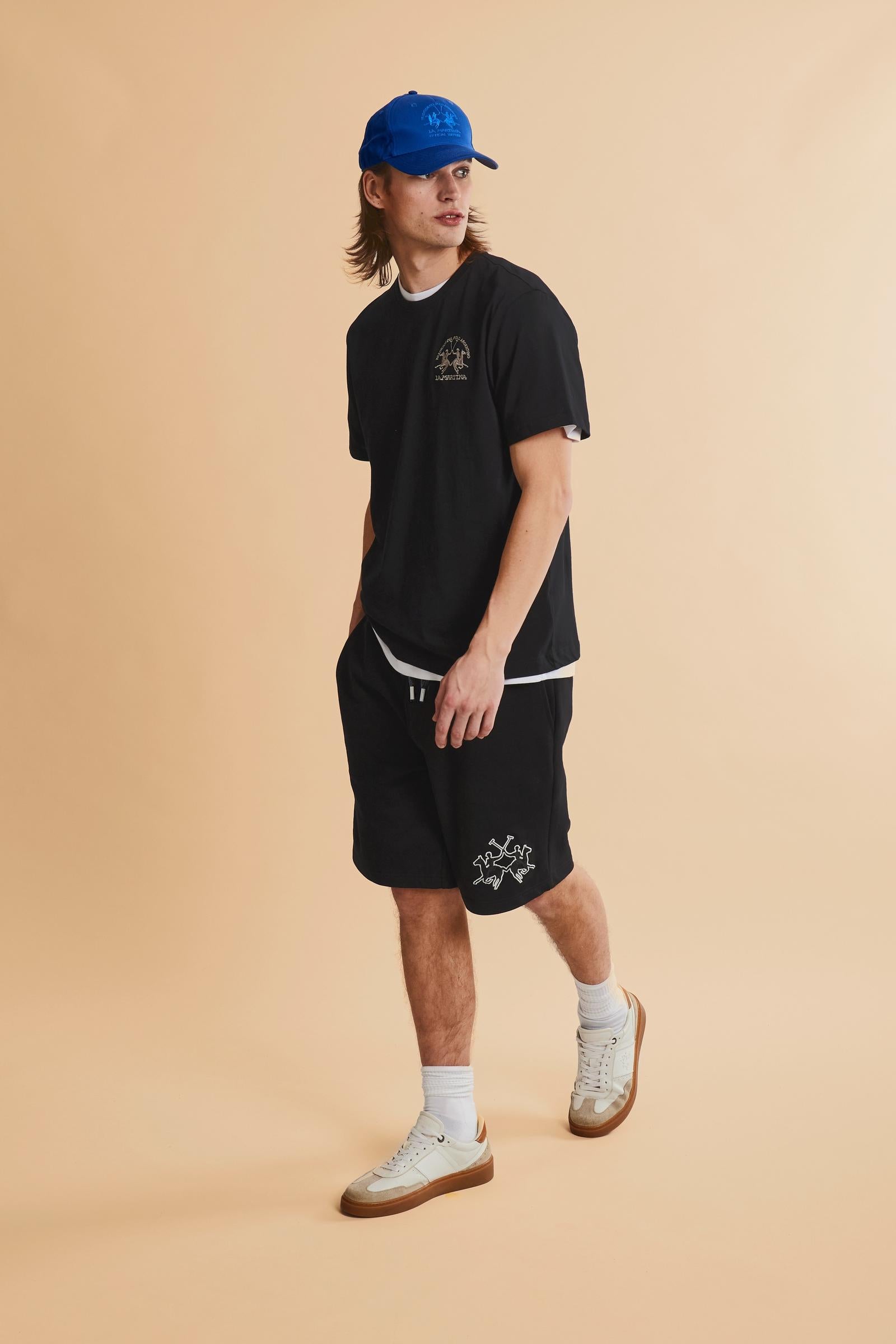 Men's bermuda shorts made from soft 100% cotton diagonal fleece. The regular relaxed cut reaches the knee and ensures maximum freedom of movement. The elastic waistband is completed by a flat tone-on-tone drawstring for adjustment. The design is finished with the brand's maxi logo embroidered in contrasting color with a 3D effect on the lower left leg. The model is wearing size L. - Black