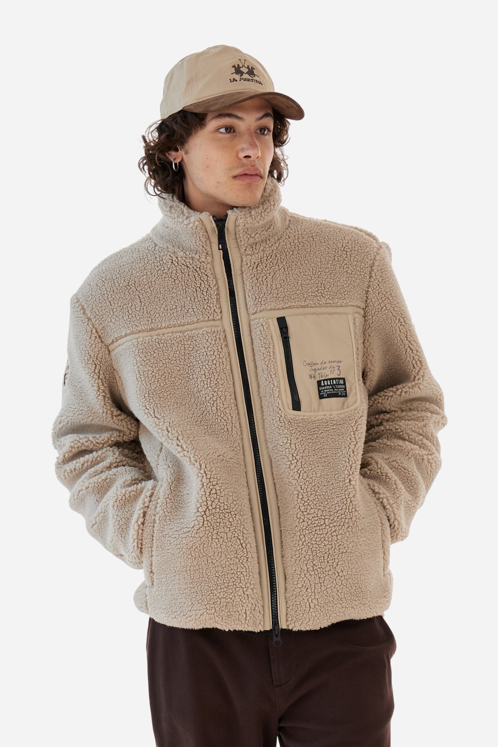 Men’s teddy jacket in 100% polyester with high collar and full lining. Front closure with customized tone-on-tone zip. Finished with matte nylon trims on seams and edges, also used for the zipped chest pocket. High collar offers extra wind protection. Patches inspired by Argentina and Jugador de Polo on sleeve and chest pocket. Regular, straight fit. Model wears size L. - Tidal Foam