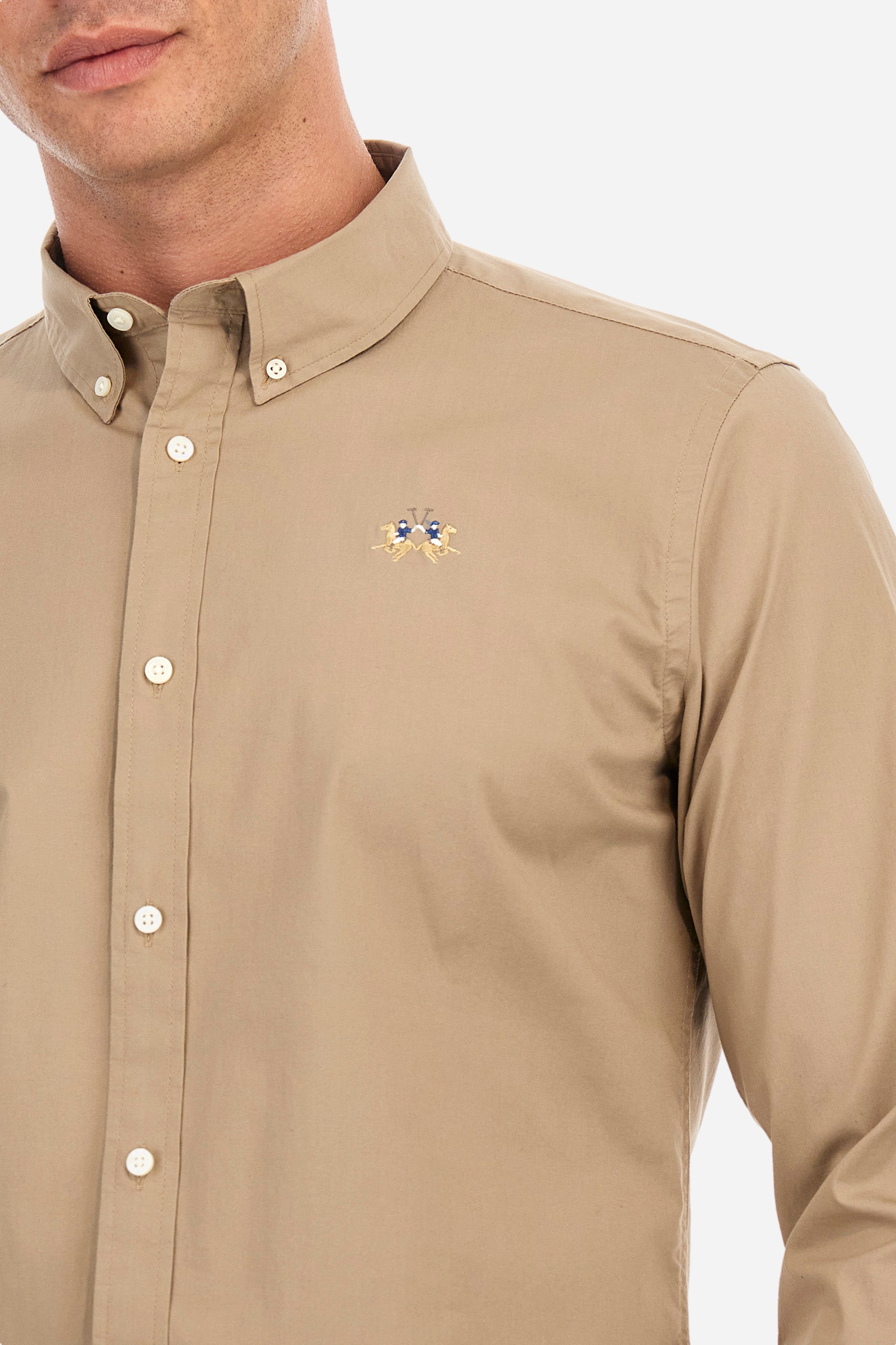 Men's single-colour shirt with long sleeves, made of stretch cotton. Button-down collar. With buttoned cuffs. Featuring a small embroidered logo on the front. Slim fit. The model is wearing a size L. - Ermine