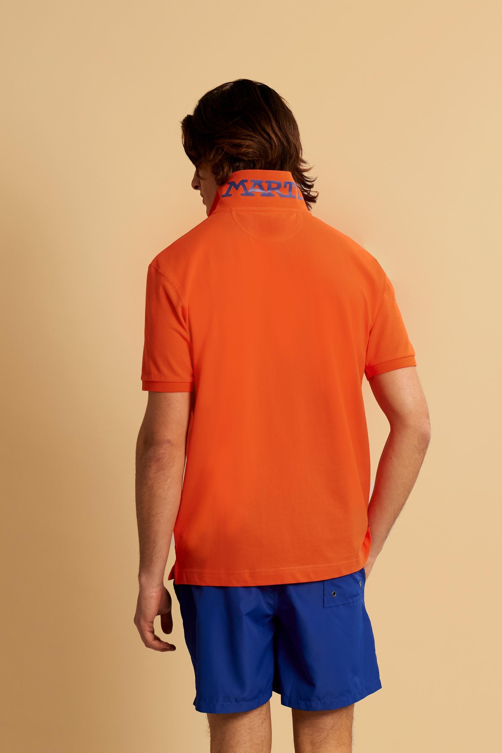 Men’s short-sleeve stretch piqué polo. Two-button placket with ribbed collar and cuffs in solid colour. Numeric patch applied on the sleeve and contrast monogram print under the collar. Small logo embroidered in contrast on the chest. Regular fit. The model wears size L. - Flame