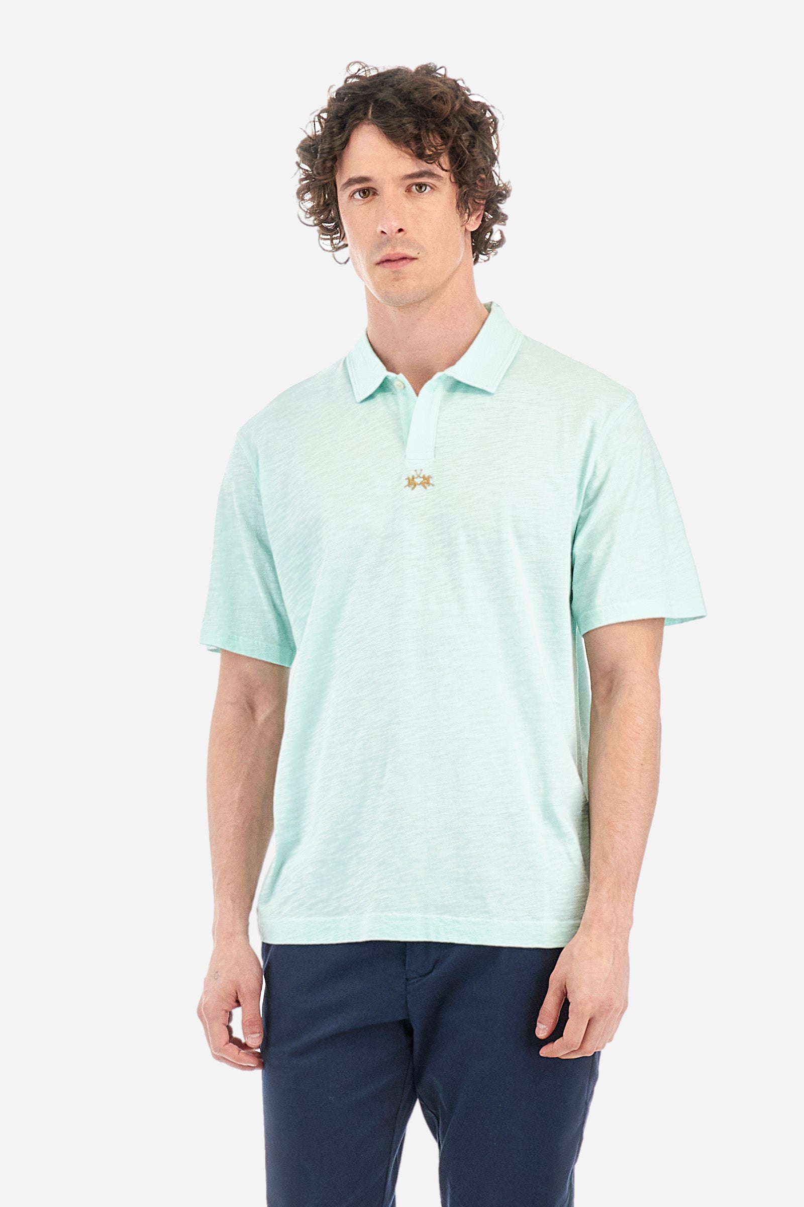 Men's single-colour short-sleeved polo shirt in 100% cotton. Fastens with a button. Tone-on-tone stitching. Pointed collar. Featuring a small embroidered logo on the front. The fit is regular. The model wears a size L. - Honeydew
