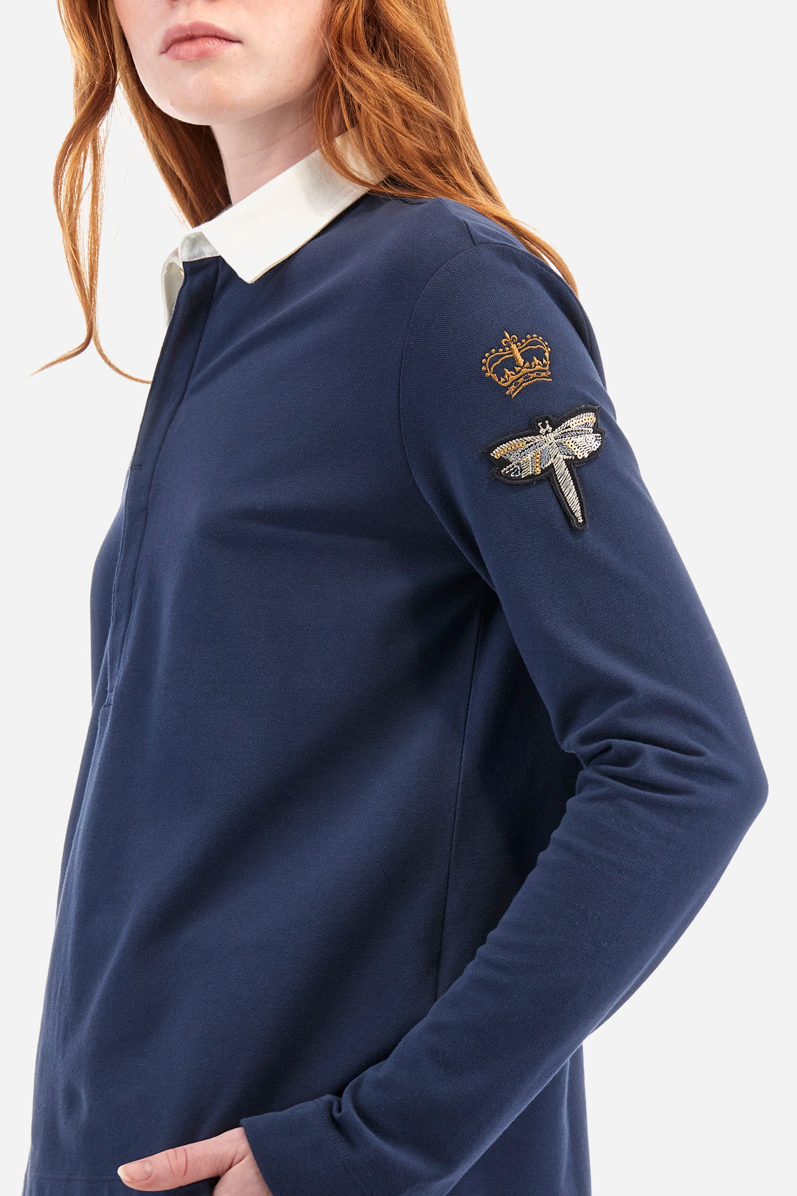 Women's long-sleeved polo shirt, made from plain stretch cotton. Shirt-style collar. Button fastening. The front is embellished with decorative prints and lettering. A crown is embroidered on one of the sleeves, in addition to an appliquéd patch depicting a dragonfly. The logo is embroidered on the other sleeve. Regular fit. The model is wearing a size 2. - Navy