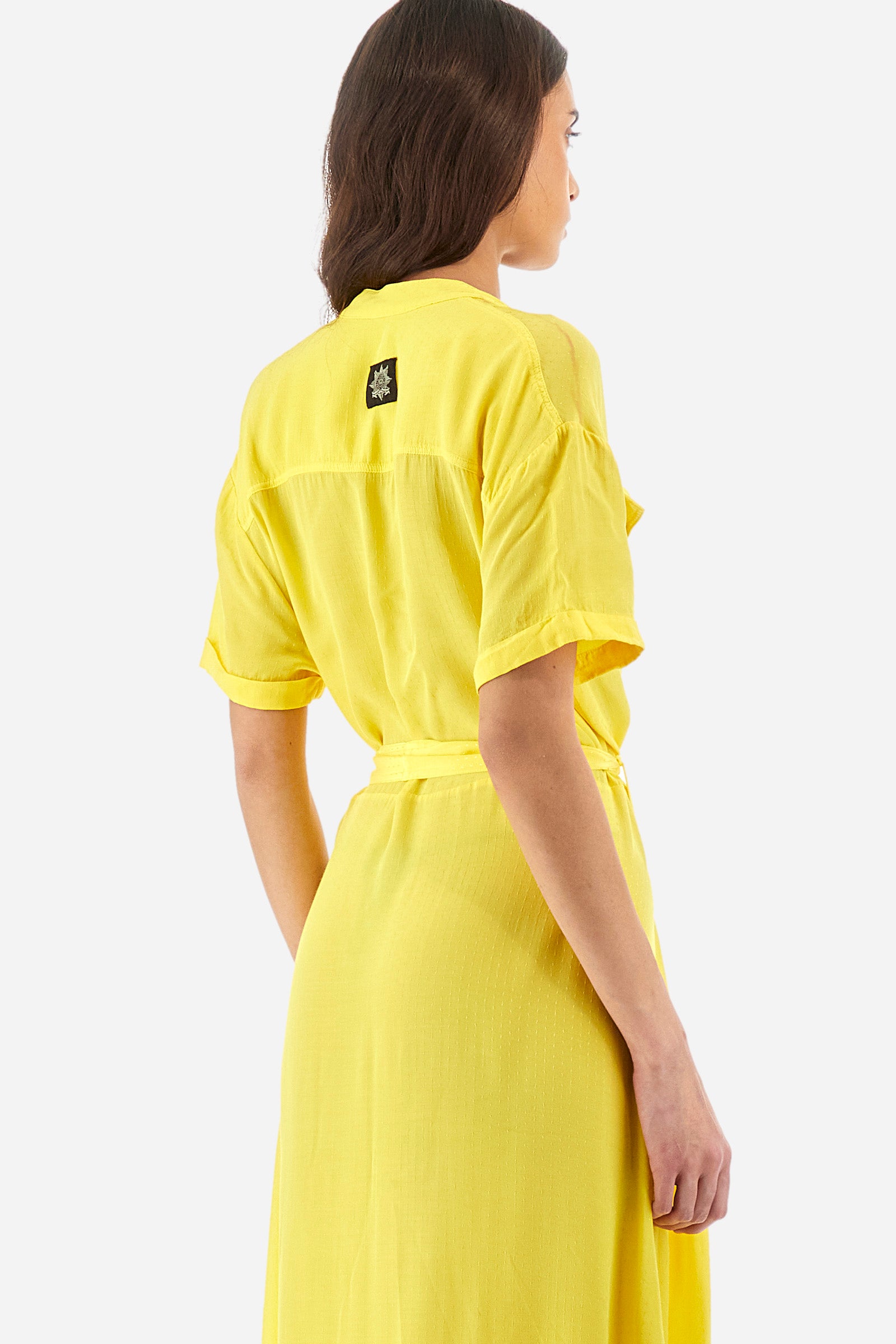Women’s dress with short sleeves in solid color with bright tone on tone details. Made of synthetic viscose satin fabric. Silhouette straight cut and soft, long to the feet. Waist marked by the belt supplied with the head. V-neck and stand-up collar. Closure with buttons that reach up to the end of the dress. Presence of two fake pockets with buttons on the chest. The patch applied on the back with the representative symbol of the Guards line. The fit is regular. The model wears an IT40 size. - Aspen Gold