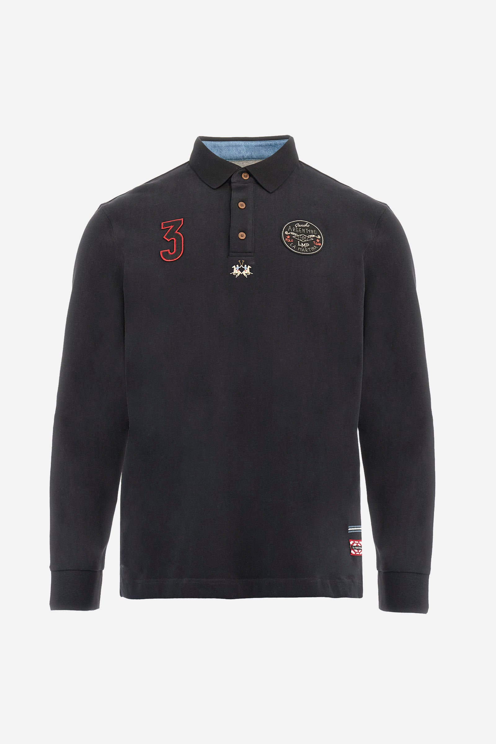 Long-sleeve polo shirt crafted from 100% high-quality cotton jersey. The velvety fabric offers a warm, cozy feel, perfect for cooler seasons. Ribbed collar and cuffs in matching tone, with a three-button personalized placket. A small multicolor embroidered logo sits below the opening, while tonal patches in different shapes and textures, inspired by Argentine culture and Gaucho tradition, decorate the chest and back. Classic regular fit. Model wears size L. - Black