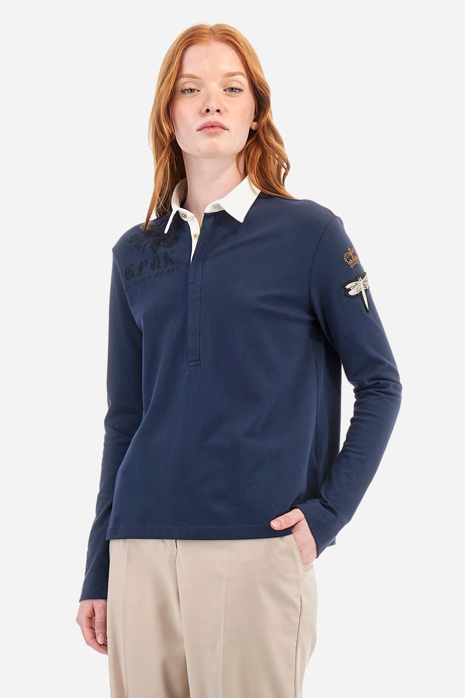 Women's long-sleeved polo shirt, made from plain stretch cotton. Shirt-style collar. Button fastening. The front is embellished with decorative prints and lettering. A crown is embroidered on one of the sleeves, in addition to an appliquéd patch depicting a dragonfly. The logo is embroidered on the other sleeve. Regular fit. The model is wearing a size 2. - Navy