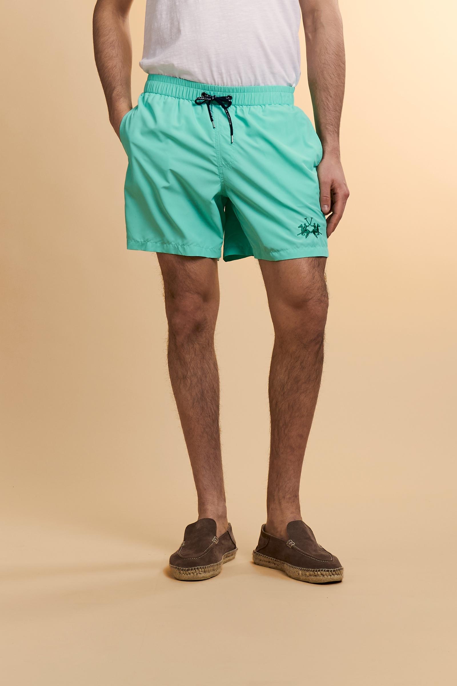 Men’s solid nylon mid-length swim shorts. Regular fit with elasticated waistband, adjustable drawstring, back pocket and embroidered logo. - Opal