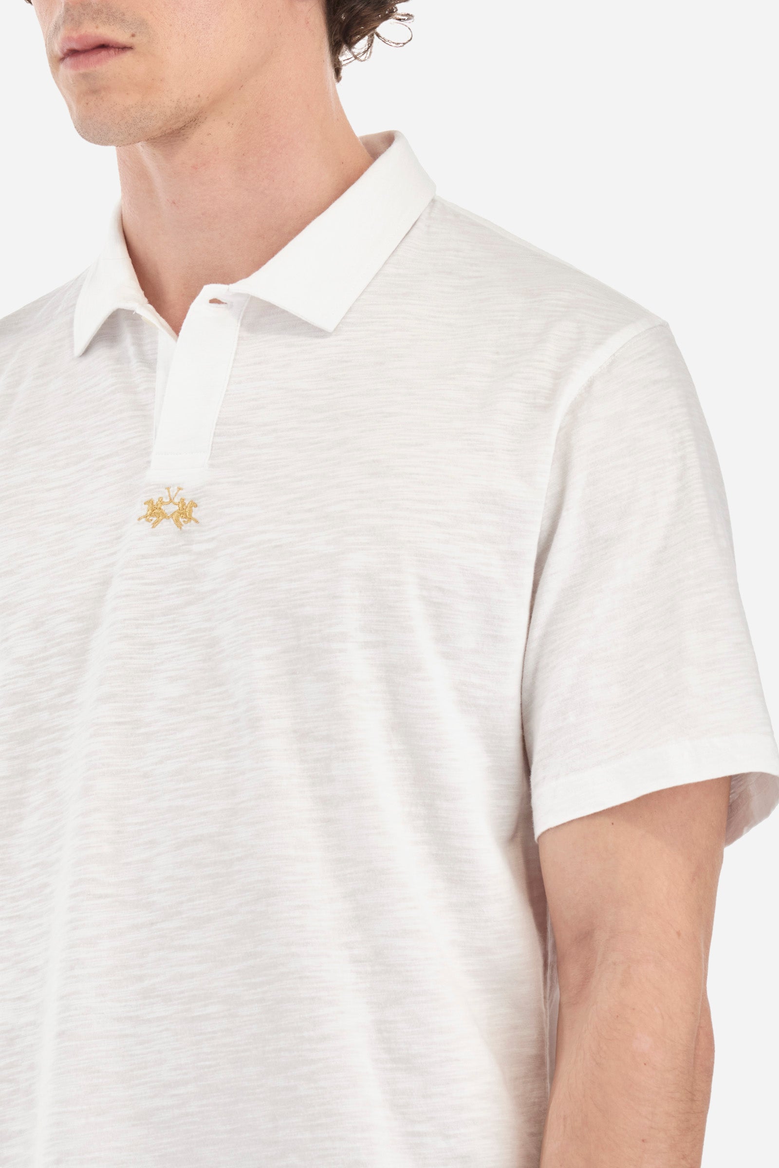 This is the iconic Polo 19-42 from La Martina. Men's short-sleeved polo shirt in solid color made of 100% slub jersey. With a regular fit, it has a collar and a double button closure while the La Martina logo is embroidered in small gold on the front under the placket. Ideal when worn with denim from the collection. Each Polo is kept in an exclusive logoed envelope and is accompanied by a certificate of guarantee. The model is 187 cm tall and wears a size L. - Optic White