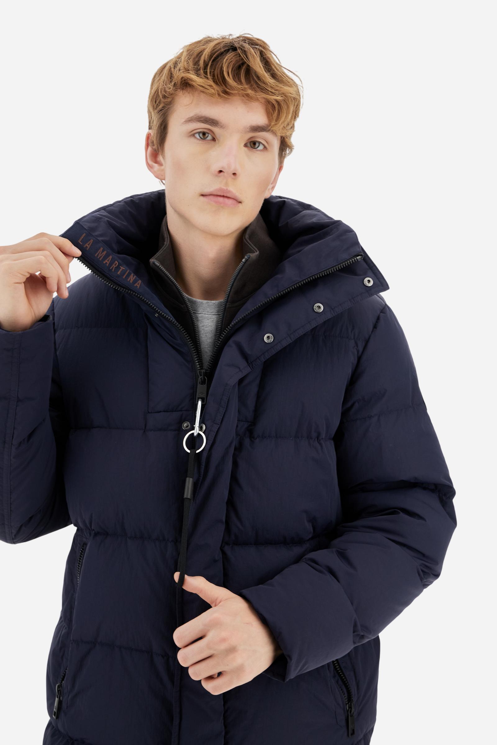 Men's long down jacket in solid crinkled nylon with detachable hood. Filled with down and fully lined in contrast, designed to provide warmth and lightness. The removable hood is adjustable with elastic drawstrings. Double zip closure with exclusive carabiner puller. Inside placket features contrasting La Martina embroidery, while a logo patch on the left sleeve completes the garment. Designed to combine urban functionality with technical performance. Regular, comfortable fit. Model wears size L. - Navy