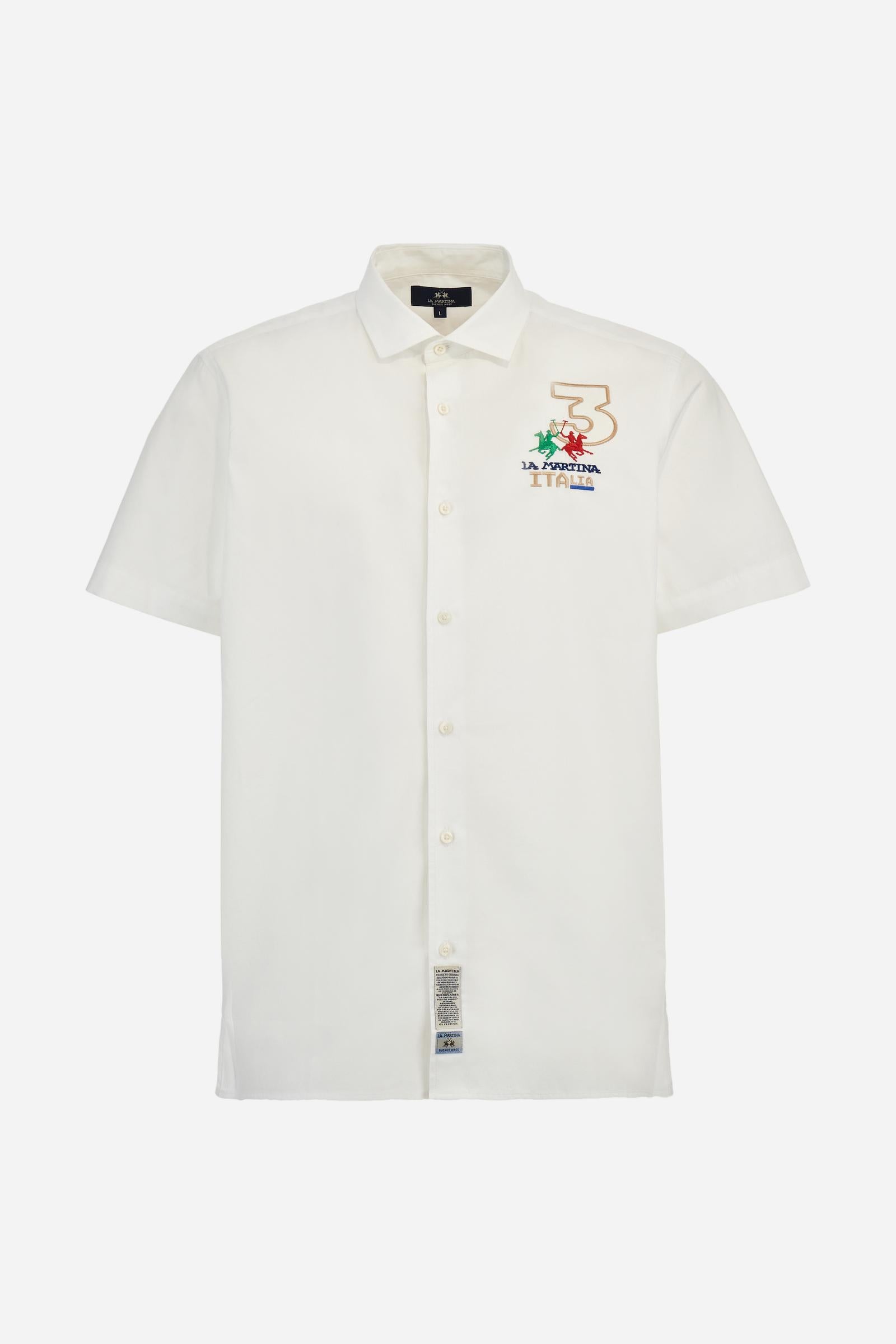 Men's plain short-sleeved shirt made from cotton poplin. Spread collar and straight hem. The embroidered logo on the chest, over the heart, is designed in the colours of the Italian flag. On the back, the combination of printing and embroidery techniques – depicting lettering, numbers and logos – are enriched with 3 ribbons in the colours of the Italian flag, appliquéd vertically. Regular fit. The model is wearing a size L. - Optic White