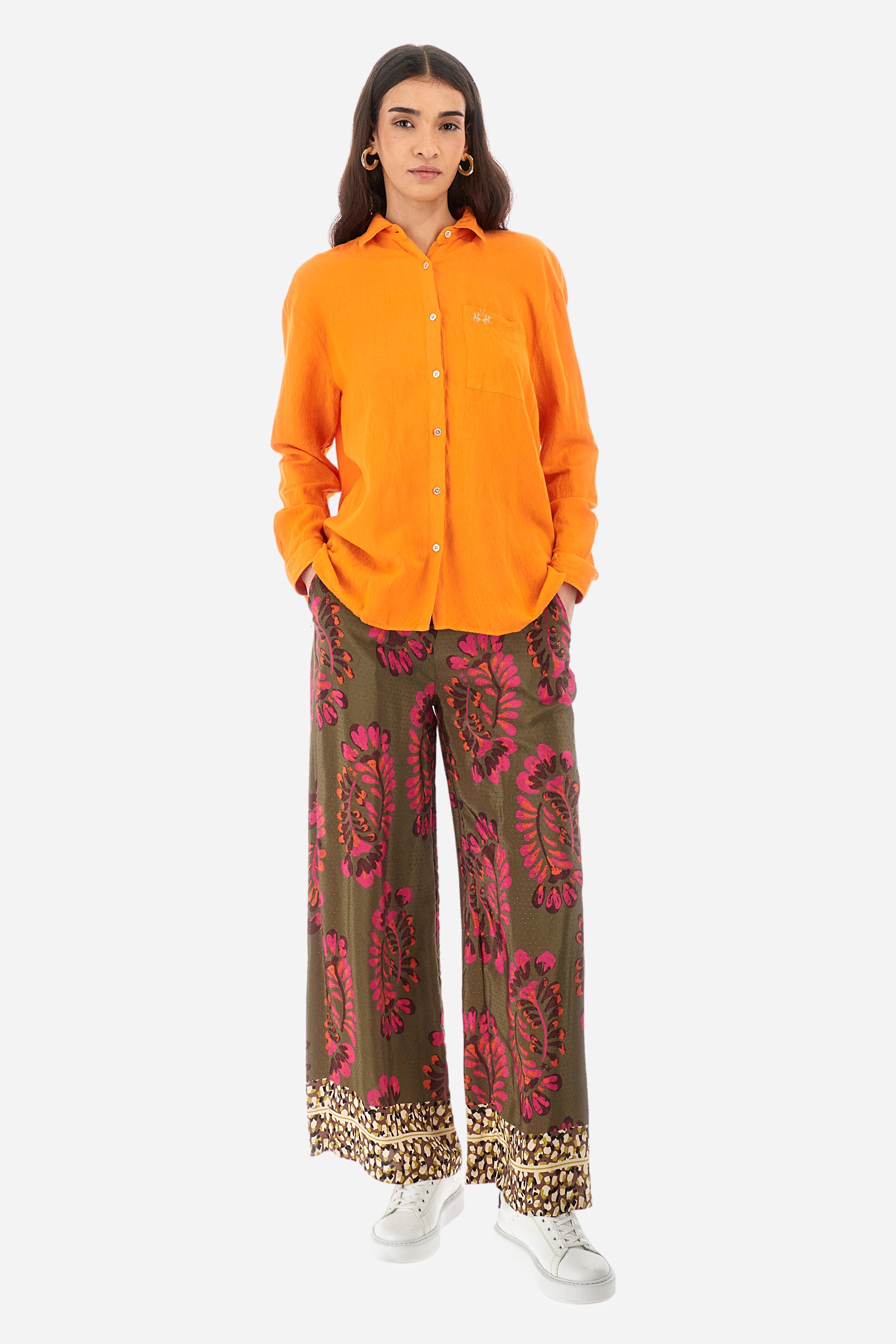 Palazzo trousers for women made of satin viscose fabric. The rich floral stamps and brilliant details on the bottom, in contrasting tones, recall the Argentina capsule collection. Elasticated waistband. Two front welt pockets. Metal label with La Martina logo sewn on the front. The fit is regular. The model wears a size 2. - Military/Hotpink/Fre