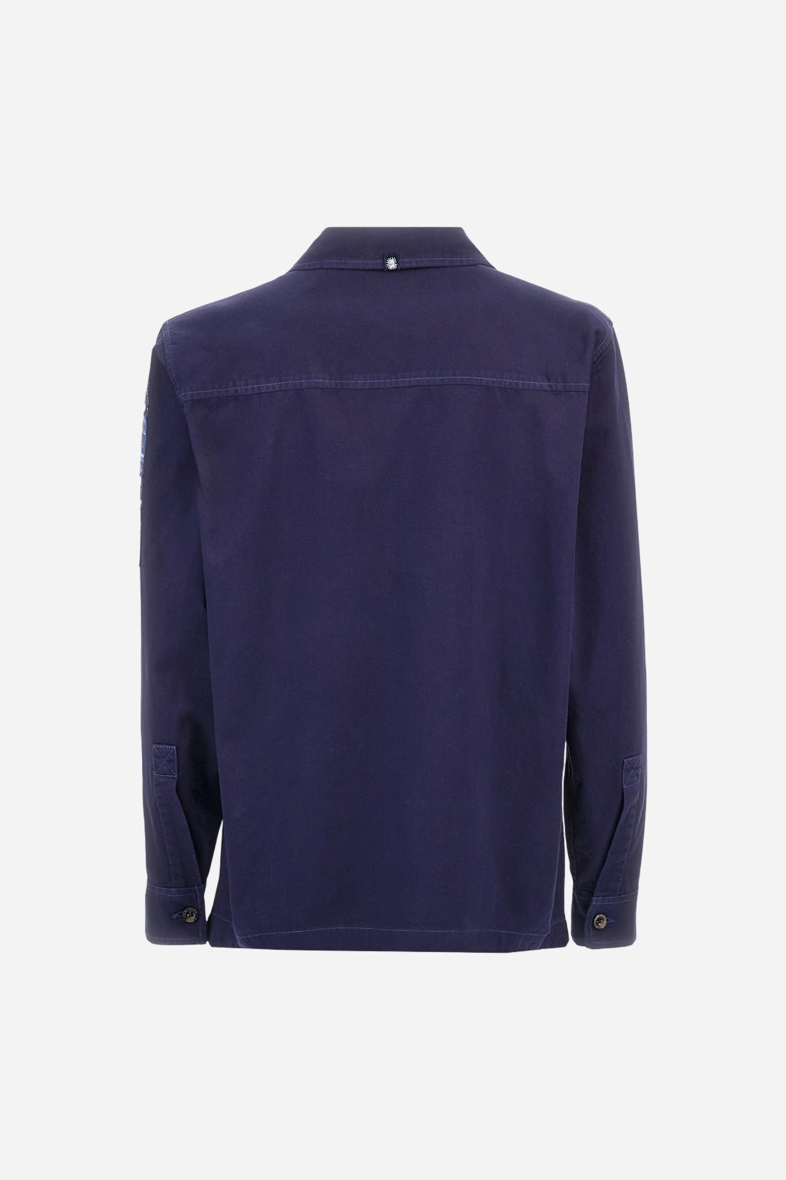 Men's single-colour long-sleeved overshirt made of 100% cotton slub twill. Bowling collar and jacket opening with inside placket, fastening with imitation horn buttons.On the shoulder and chest the embroidery is in tone with the garment, Argentina lettering embroidered on one shoulder. There are several patches applied on the left sleeve. A tone-on-tone logo is embroidered on the front. Regular fit. The model is wearing a size L. - Deep Cobalt