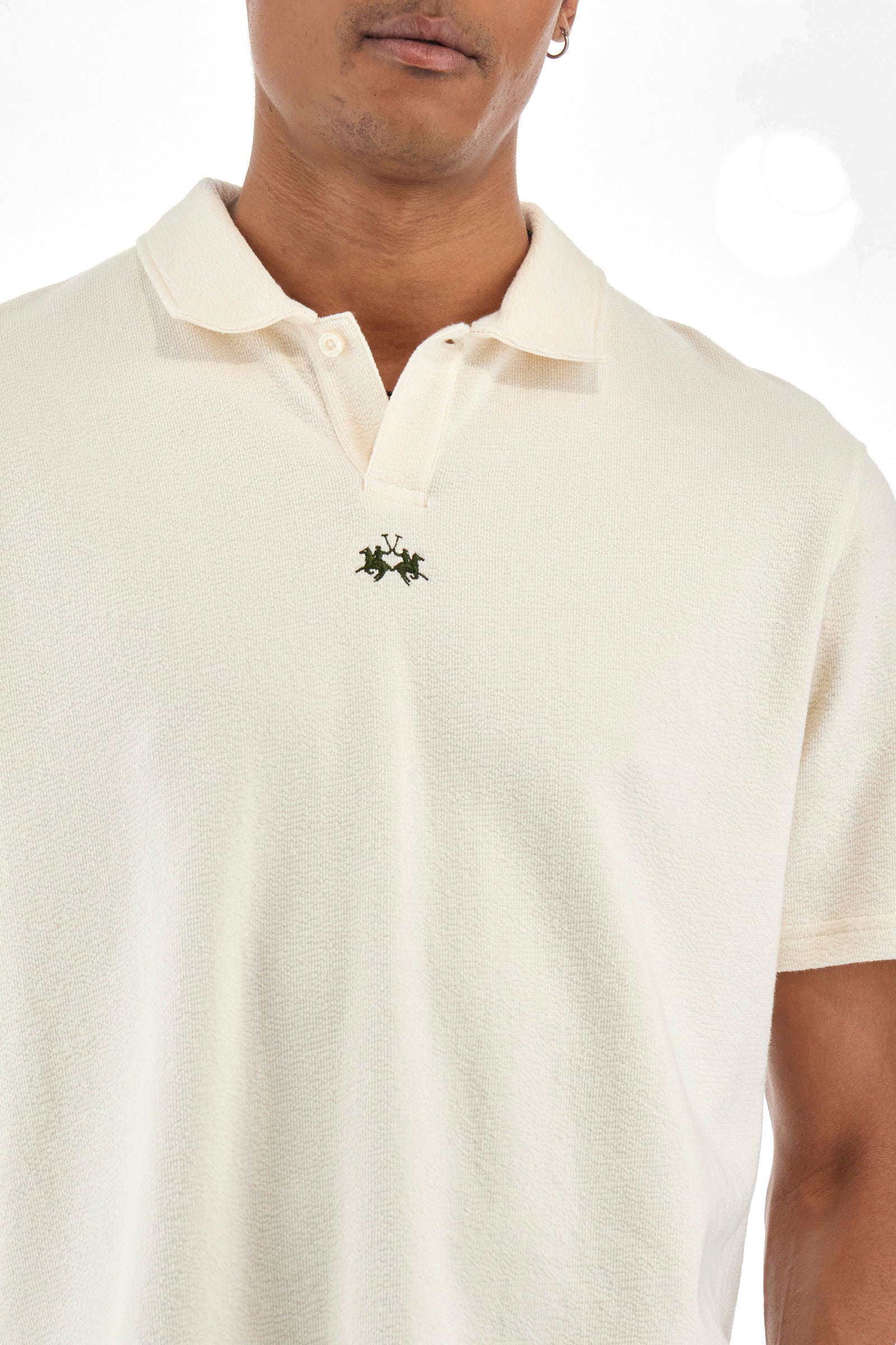 Men's single-colour short-sleeved polo shirt in 100% cotton. Fastens with a button. Tone-on-tone stitching. Pointed collar. Featuring a small embroidered logo on the front. The fit is regular. The model wears a size L. - Off White